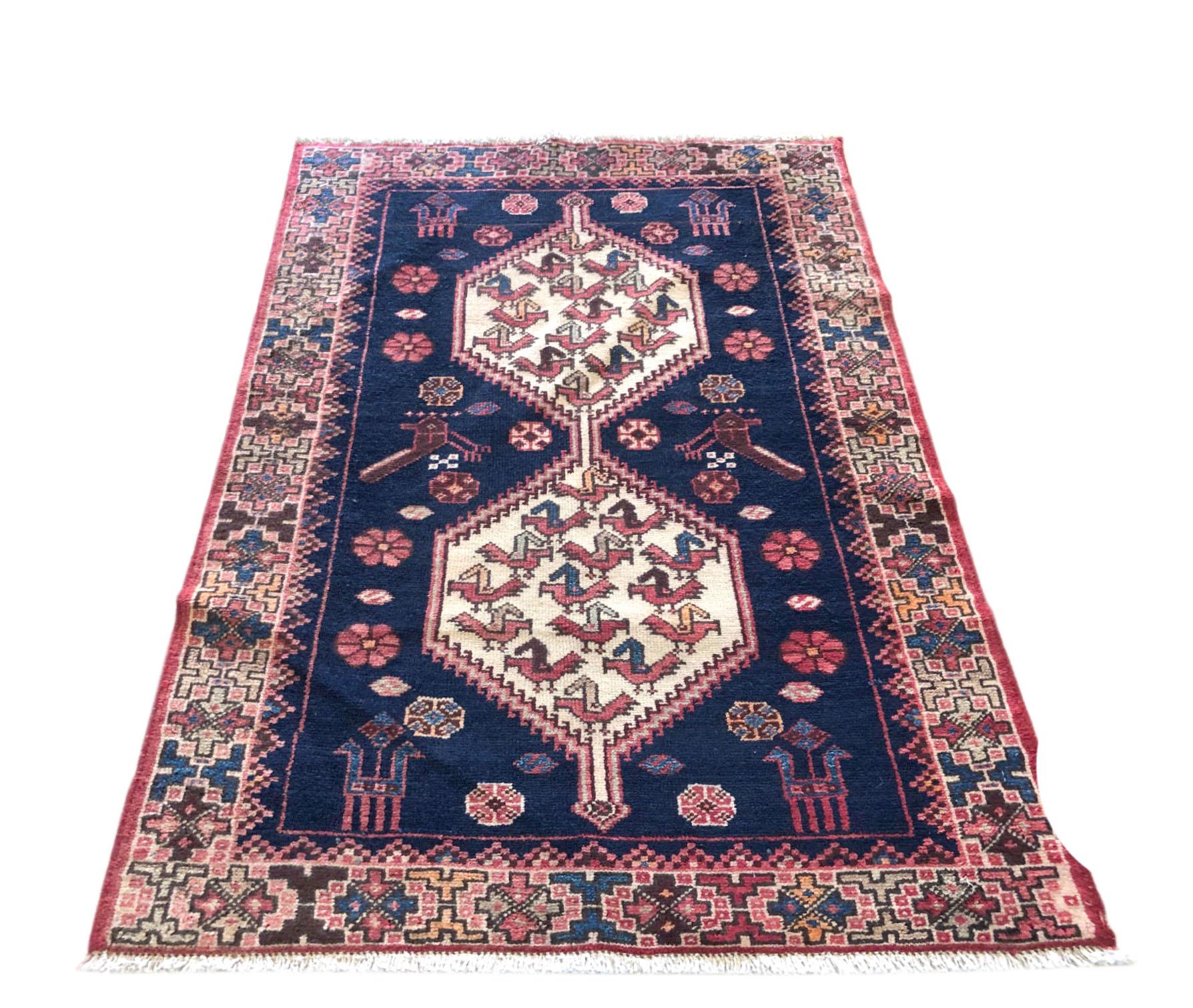 This rug is knotted in the province of Azarbayjan in North West of Iran. The design is geometric with repeated medallion. The pile is wool with cotton foundation. The base color is blue and with multi-color border. The design and color combination
