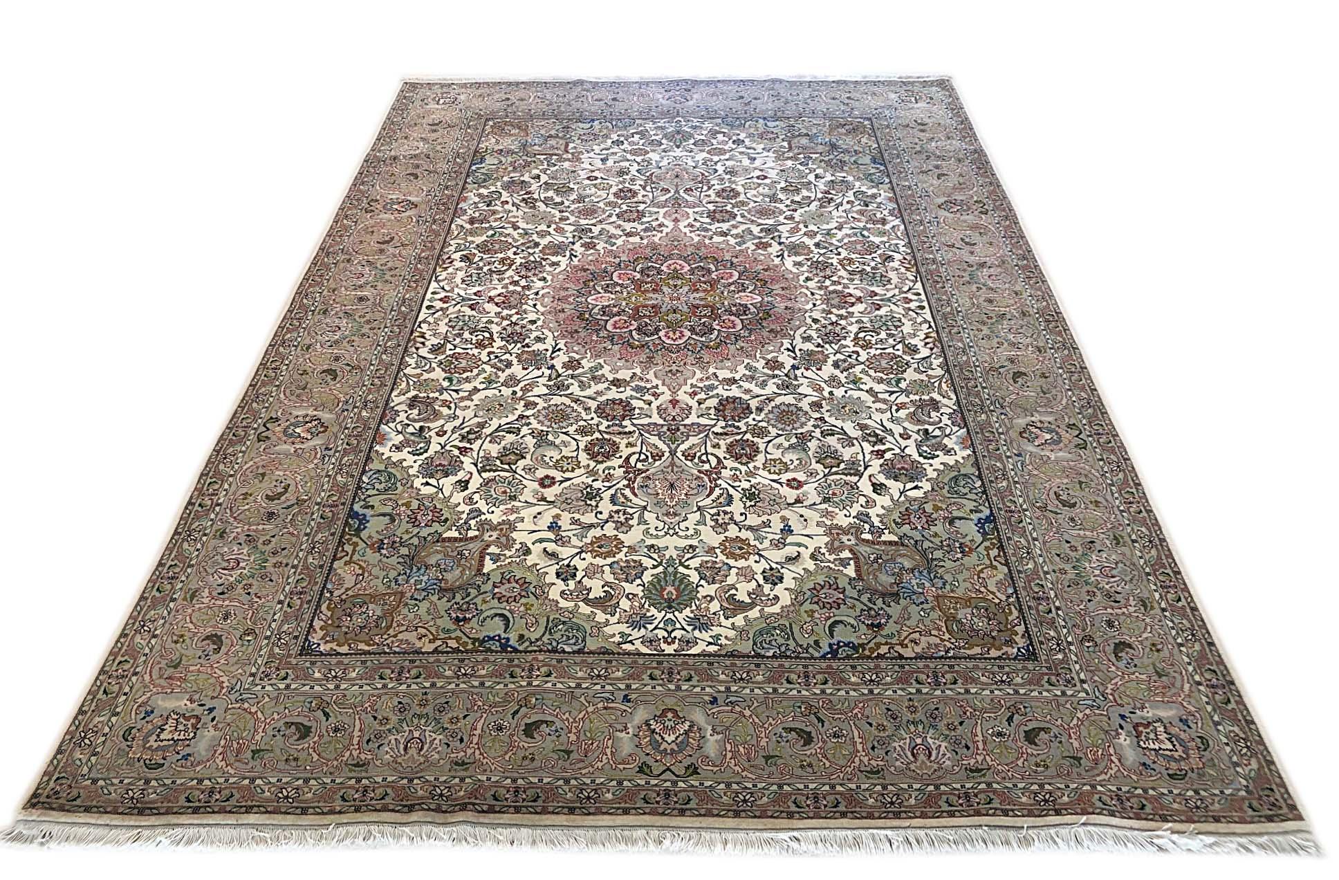 This Persian Tabriz rug has wool and silk pile and cotton foundation. This beautiful rug features a floral rug pattern that defines the elements in a unique way. The base color is cream and border is taupe. The size is 6 feet 6 inches wide and 10