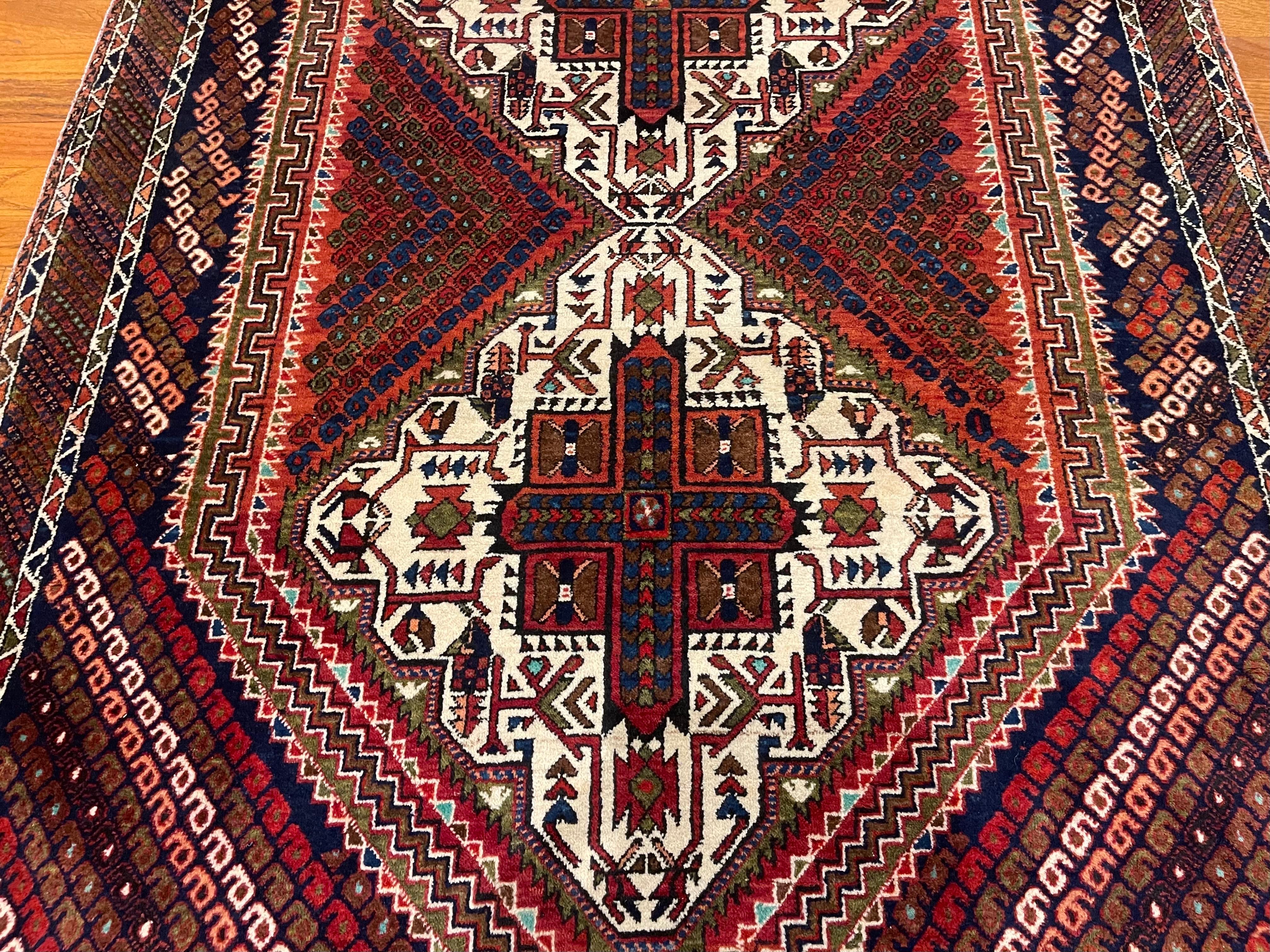 This rug is an authentic rug from Iran. Afshars are tribal rugs that are hand woven by the Afshar people in southern Iran. The pile is wool and foundation is cotton. The base color is a cream with accents of rust, green, blue and brown throughout