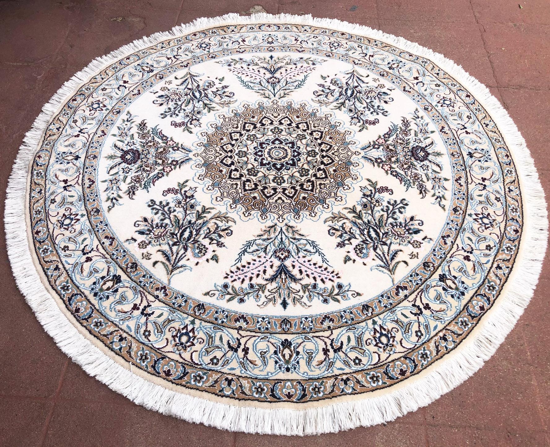 This authentic Persian round handmade Nain (9 LA) rug has wool and silk pile with cotton foundation. Nain is a city in Iran that is well known for producing fine handmade rug. This rug has medallion floral design. The base and border colors are