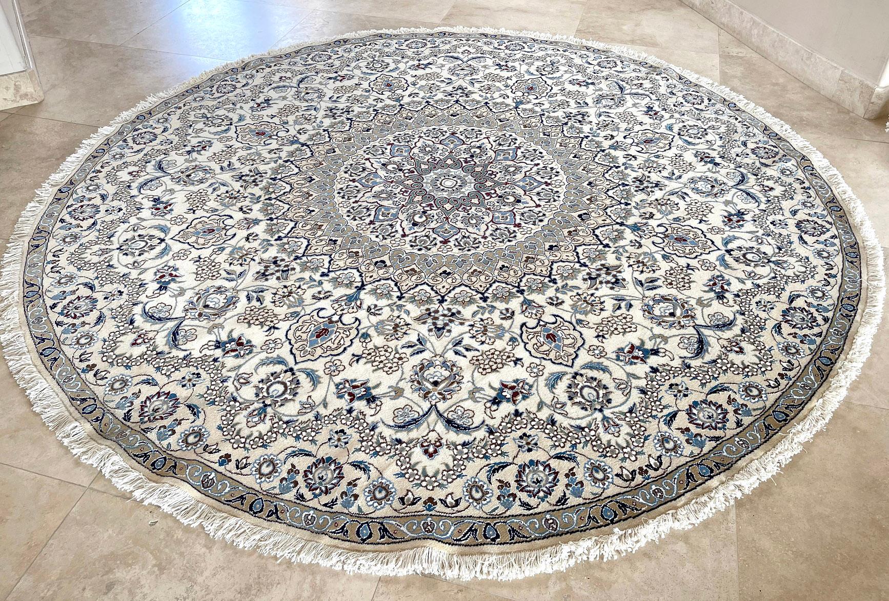 This authentic Persian round hand-made Nain (9 LA) rug has wool and silk pile with cotton foundation. Nain is a city in Iran that is well known for producing fine handmade rug. This rug has medallion floral design. The base color and border are