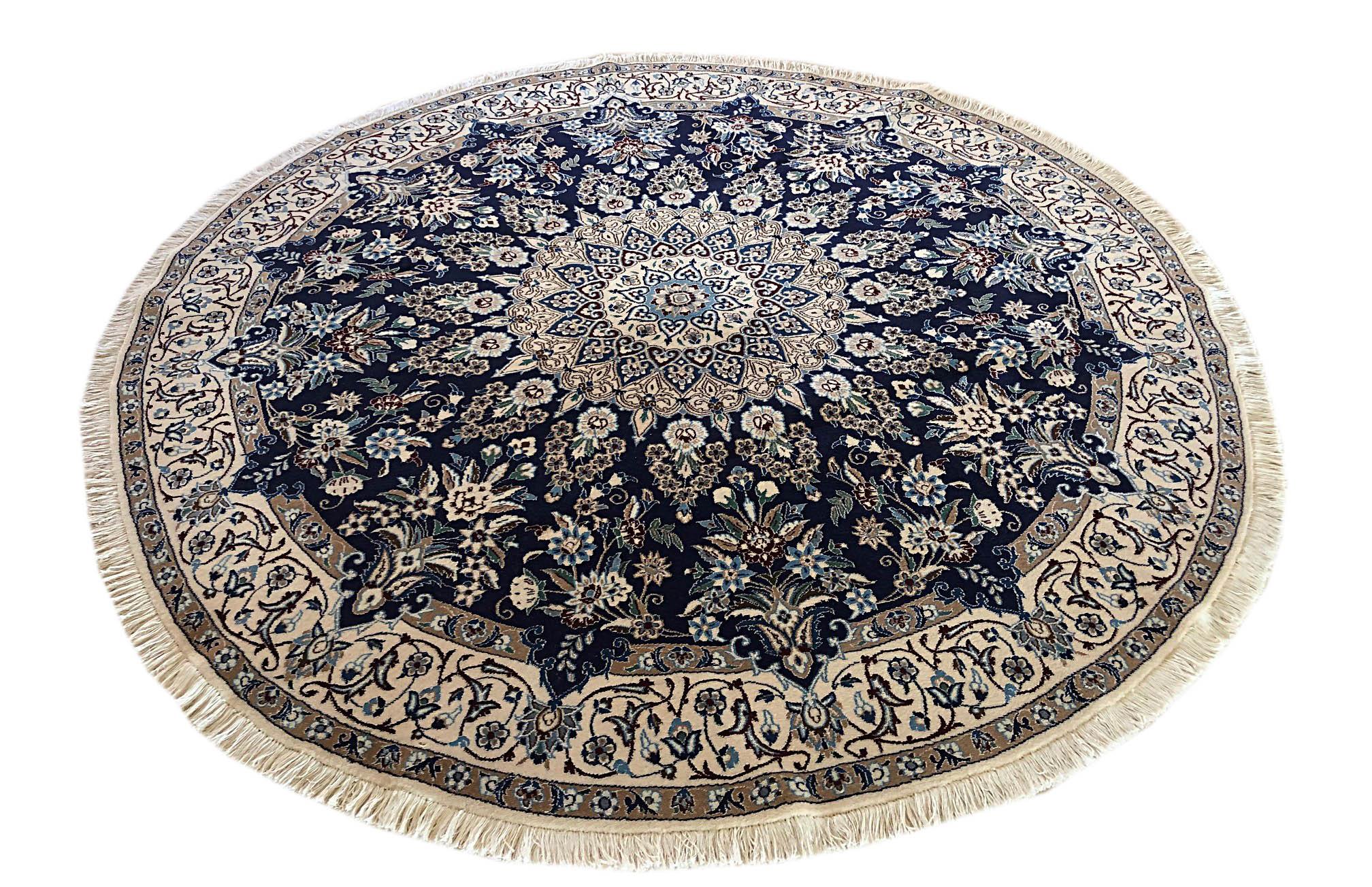 This authentic Persian round handmade Nain (9 LA) rug has wool and silk pile with cotton foundation. Nain is a city in Iran that is well known for producing Fine handmade rug. This rug has medallion floral design. The base color is dark blue and