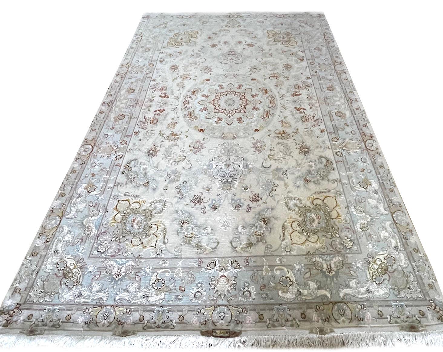 Ti presentiamo un pezzo straordinario, un tappeto persiano Tabriz annodato a mano con un disegno floreale e un medaglione molto particolare. Questo pezzo presenta un vello di lana e seta e un fondo di seta, che assicurano una lunga durata e una