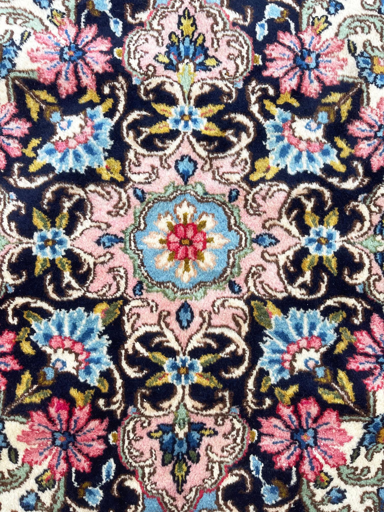 Ce tapis fait à la main provient de Kirman (Kerman) qui sont l'une des classifications traditionnelles des tapis persans. Cette pièce a des poils en laine avec une base en coton. Le motif est semi-floral et présente une grande résistance à la