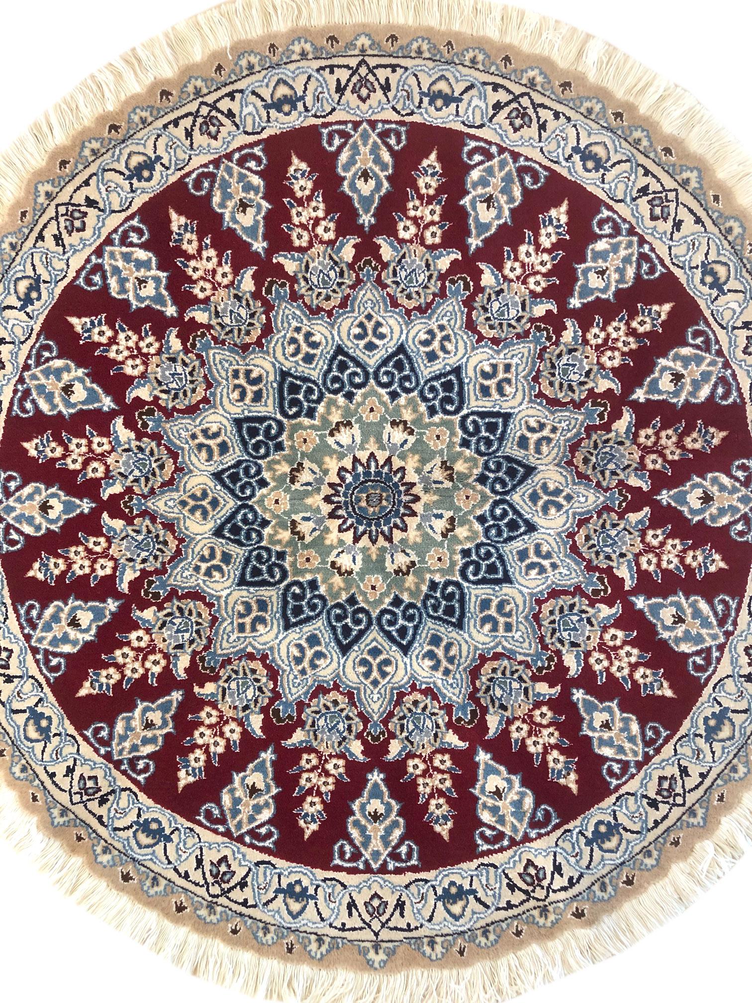 Dieser authentische runde, handgefertigte persische Nain (9 LA) Teppich hat einen Flor aus Wolle und Seide mit Baumwollgrund. Nain ist eine Stadt im Iran, die für die Herstellung feiner handgefertigter Teppiche bekannt ist. Dieser Teppich hat ein