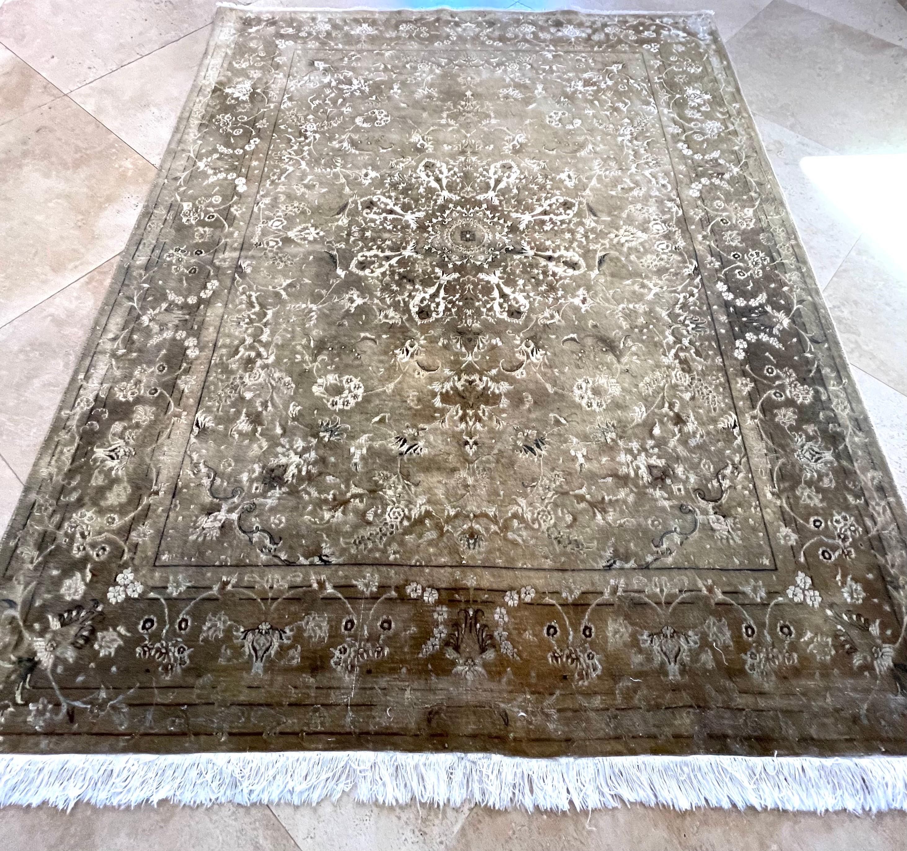 This rug is a hand-knotted Persian Tabriz rug with wool and silk pile and cotton foundation. Tabriz is one of the oldest rug weaving centers and makes a huge diversity of types of rugs. This rug features a medallion with floral pattern with a unique