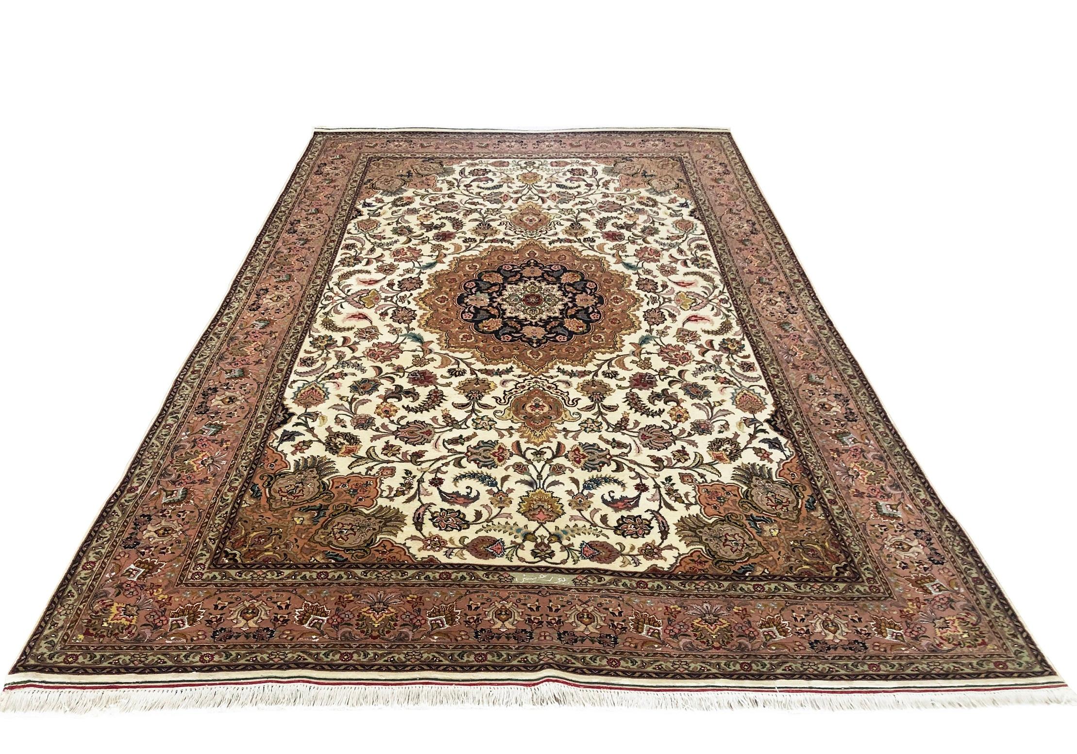 This rug is a hand knotted Persian Tabriz with floral design, signed by Pour Hosseini. The pile is wool and silk with cotton foundation. The size is 6 feet 6 inches wide by feet 9 feet 9 inches tall. The base color is cream and the border is mauve