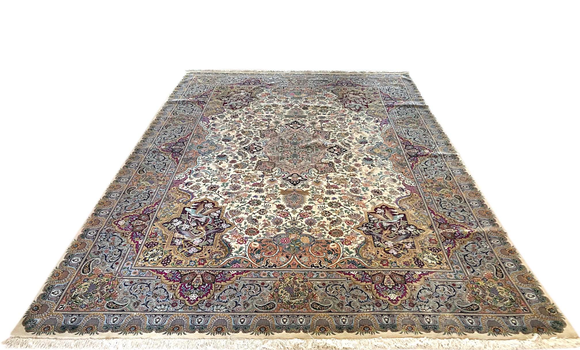 This stunning piece is a hand knotted Persian Tabriz rug with floral design and a very unique oval medallion. The pile is wool and silk with silk foundation. The size is 8 feet 2 inches wide by feet 11 feet 5 inches tall. The base color is cream and