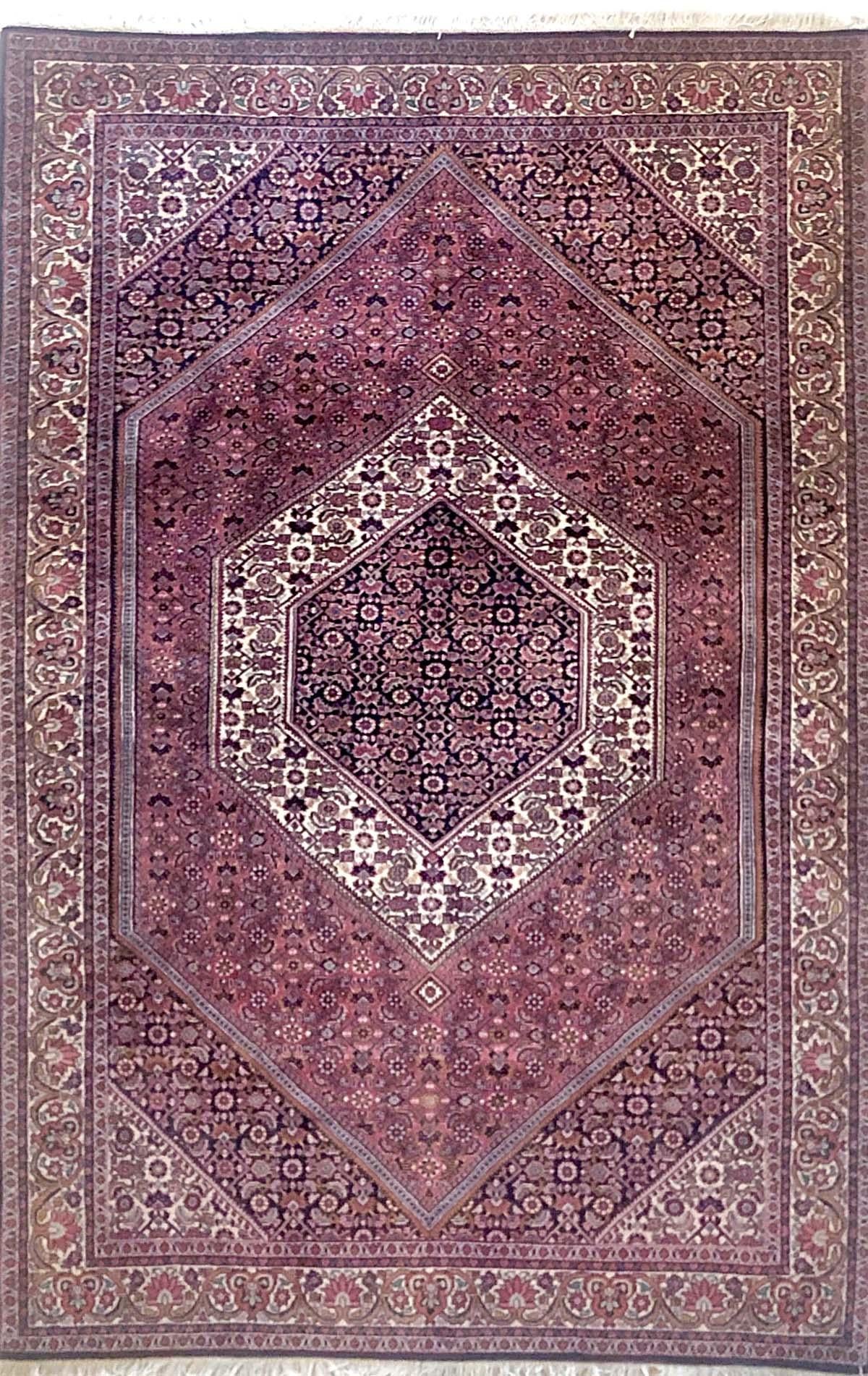 This piece is a handmade Persian Bijar rug. The pile is wool with cotton foundation. The base color is red, with indigo blue border. This rug has highly detailed design with diamond medallion. Bijar rugs are well-known for their craftsmanship and