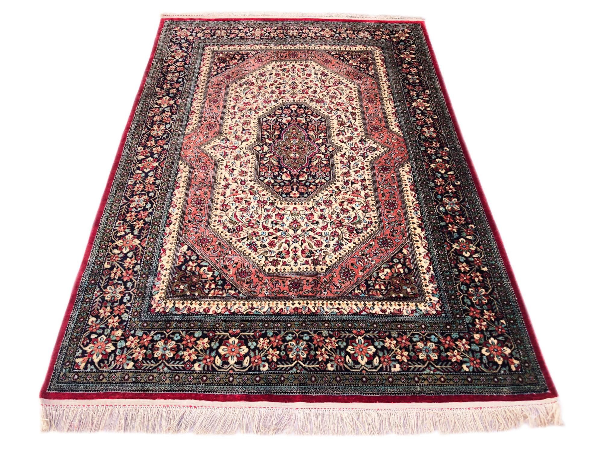 This authentic Persian Qum rug has silk pile and silk foundation. The color combination in this rug is outstanding. The base color is cream and the border is black. The design in this piece is an unusual semi geometric medallion with floral pattern.