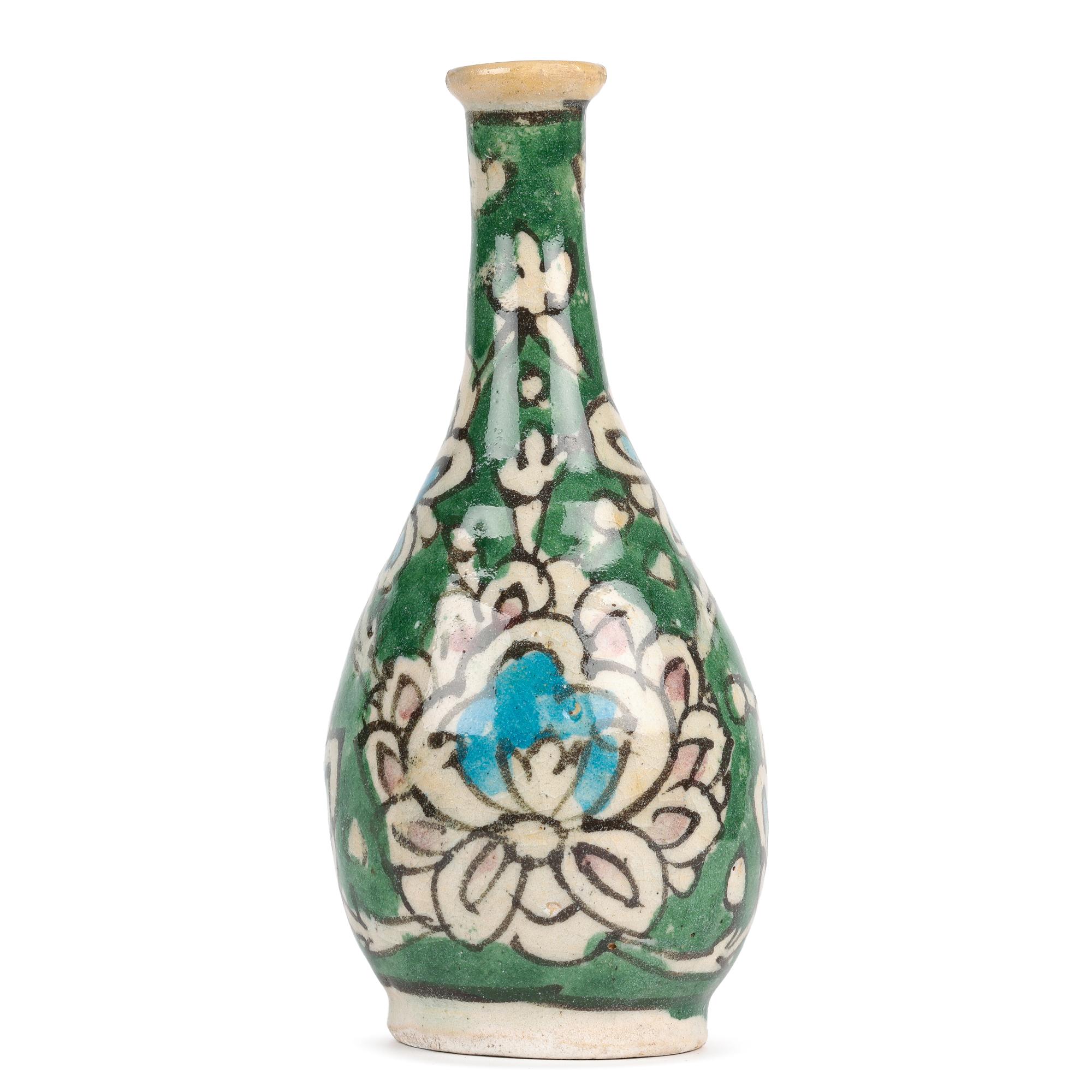 Issu d'une petite collection de cinq vases en poterie persane peints à la main, cet élégant vase en faïence en forme de bouteille peint à la main de motifs floraux d'artichauts date du début ou du milieu du 20e siècle. Le vase, légèrement empoté,