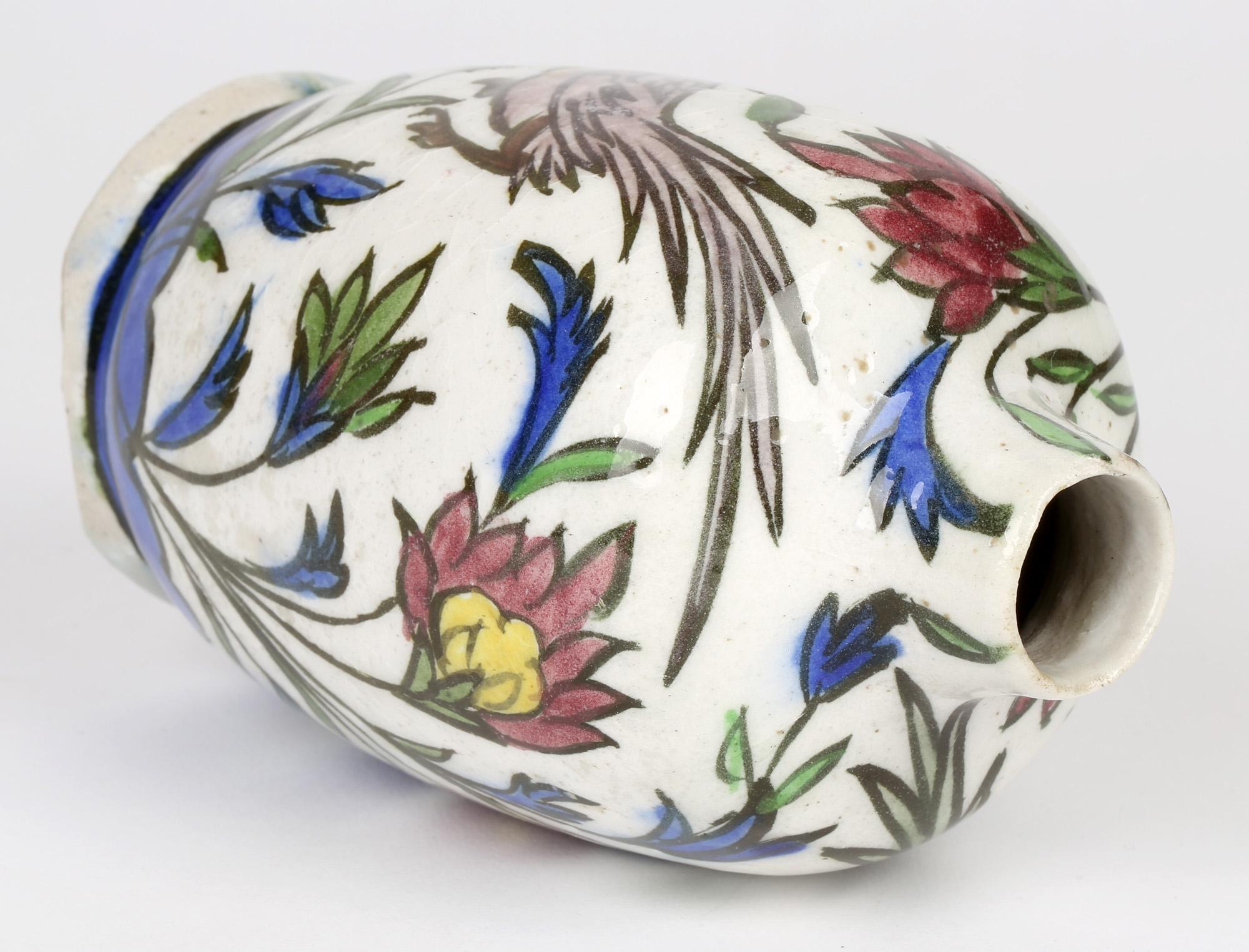 Issu d'une petite collection de cinq vases en poterie perse peints à la main, cet élégant vase en forme de bouteille en faïence peint à la main avec une poule et un coq au milieu de tiges fleuries et datant du début ou du milieu du 20e siècle. Le