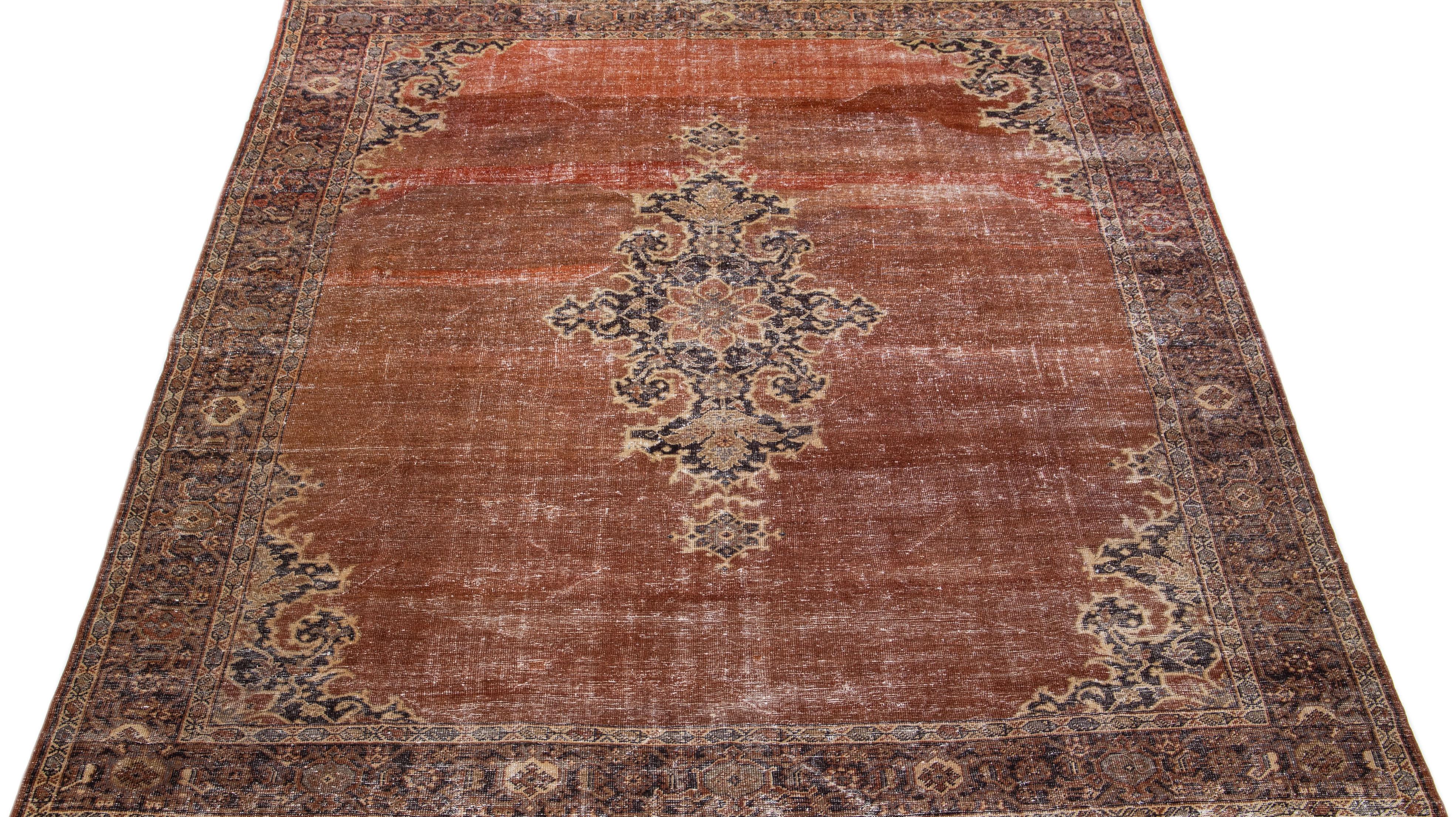 Beautiful antique Persian hand-knotted wool rug with a copper color field. This piece has a designed frame with tan and brown accents in a gorgeous all-over design.

This rug measures: 9'8' x 11'6