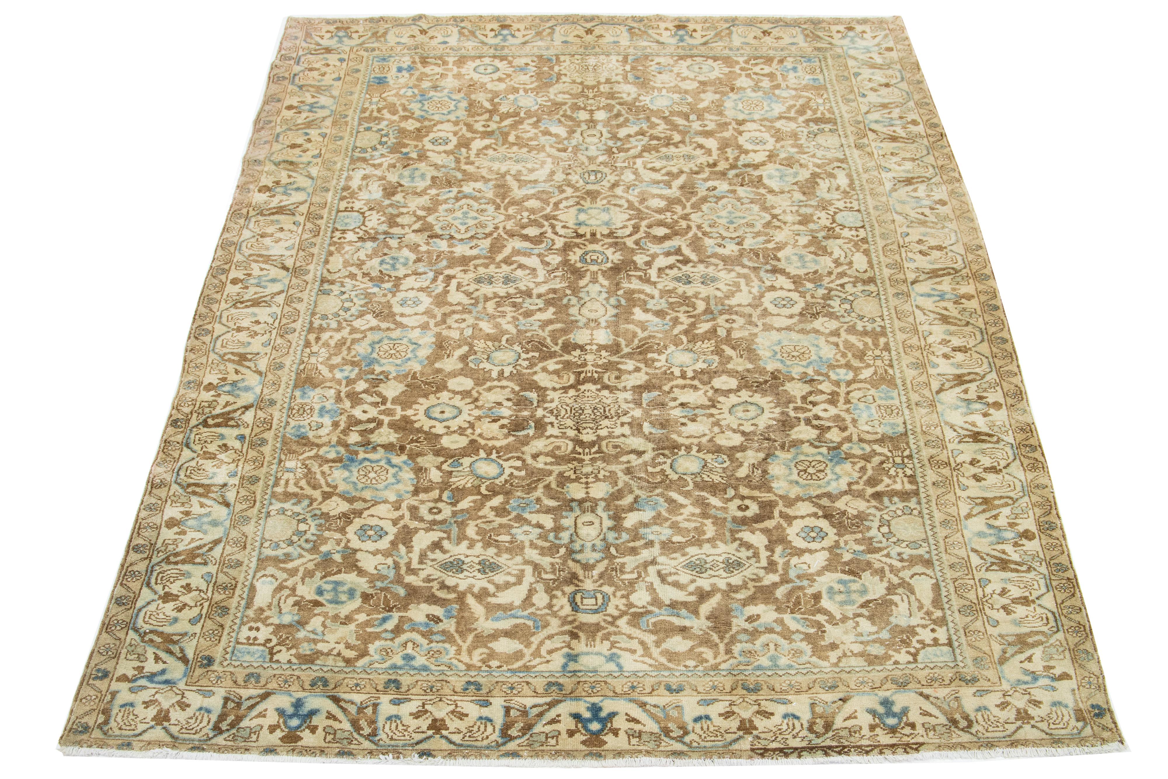 A hand-knotted wool antique Persian Heriz rug with a blue and beige all-over pattern on a brown field.

This rug measures 7'1' x 10'2