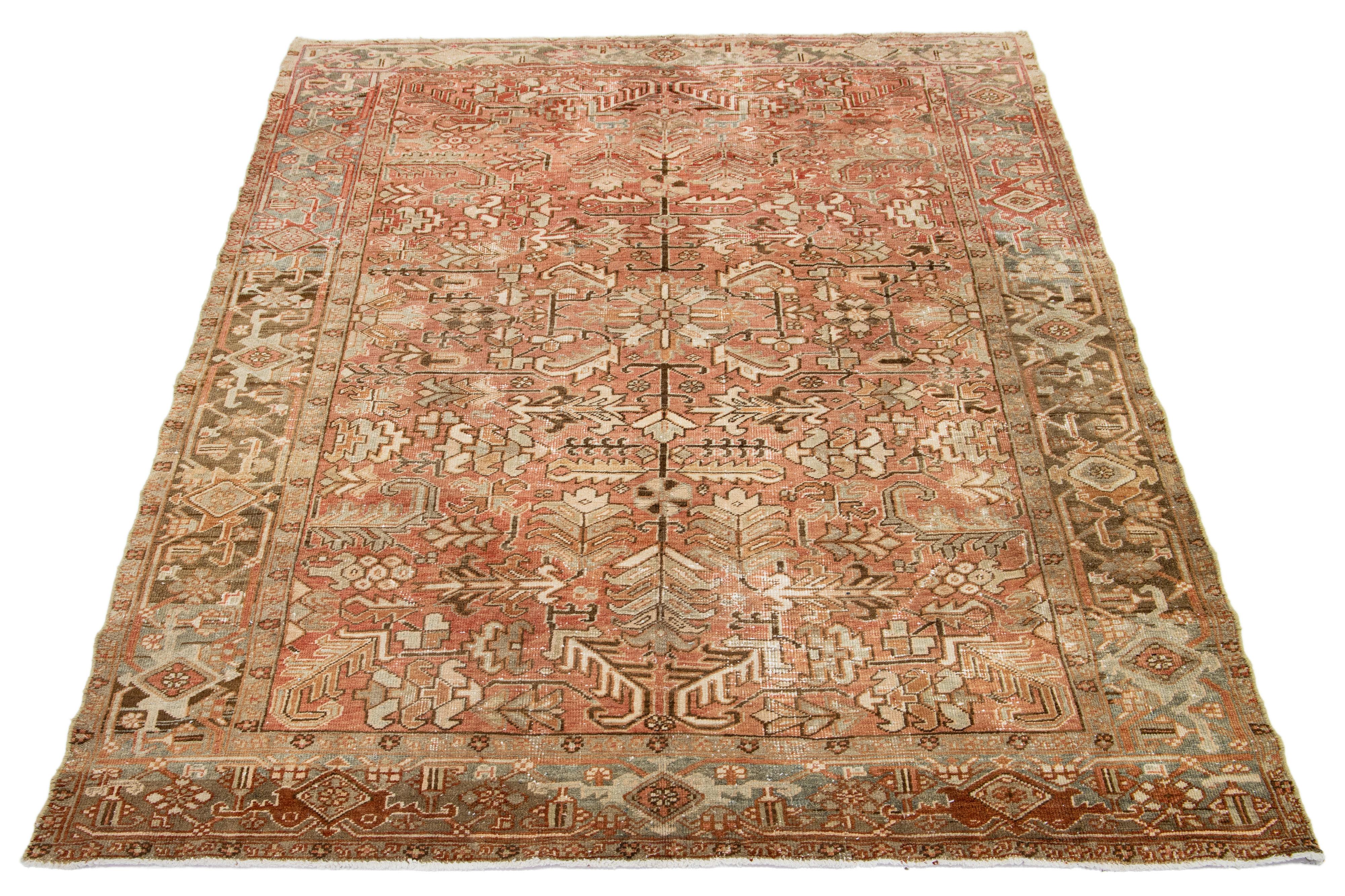 Dieser antike persische Heriz-Teppich zeichnet sich durch ein fesselndes Allover-Muster mit Blau-, Beige- und Brauntönen auf einem pfirsichfarbenen Feld aus. Es wird aus Wolle handgeknüpft.

Dieser Teppich misst 6'9