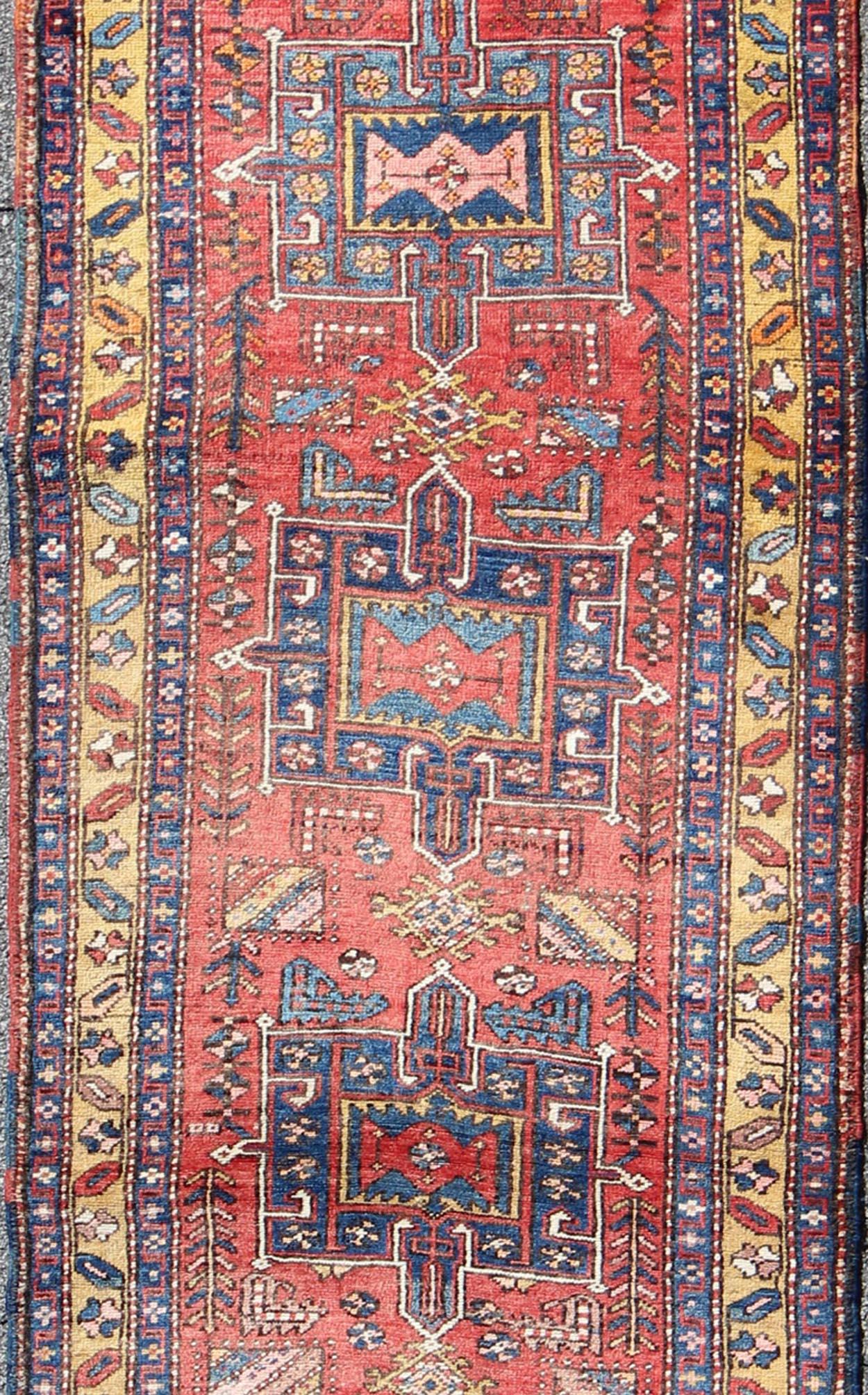 Semi antique Heriz runner rug in soft red, blue and yellow colors, rug/KB-SP-2127 . This Semi antique Heriz runner features a geometric medallion design rendered in red, blue, and yellow tones. 

Measures: 3'6 x 11.
