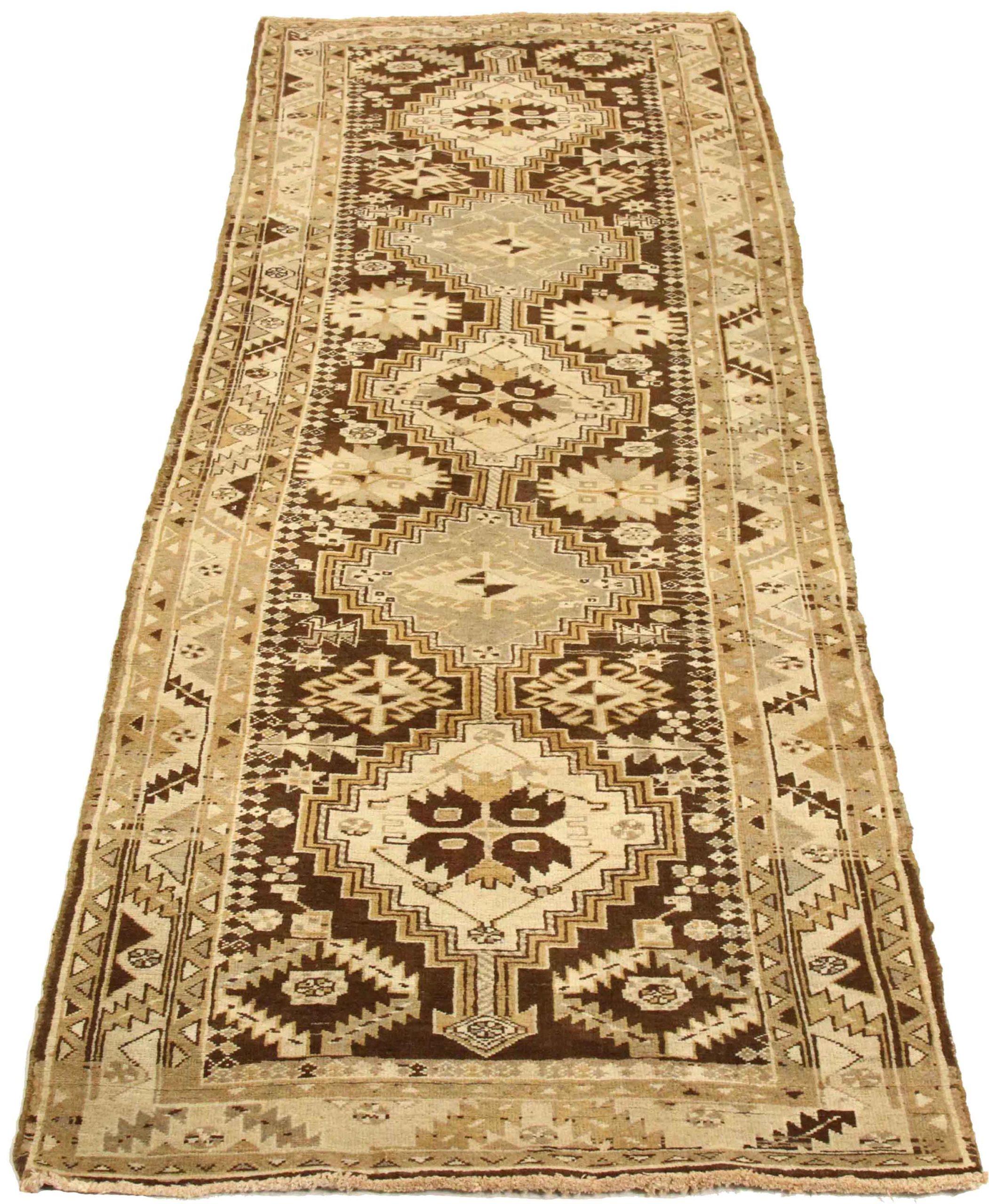 Entdecken Sie die Eleganz des persischen Heriz mit Läufer aus der Zeit um 1910. Dieses exklusive Design aus Wolle und Braun-Elfenbein ist perfekt, um Ihren Raum zu verschönern.