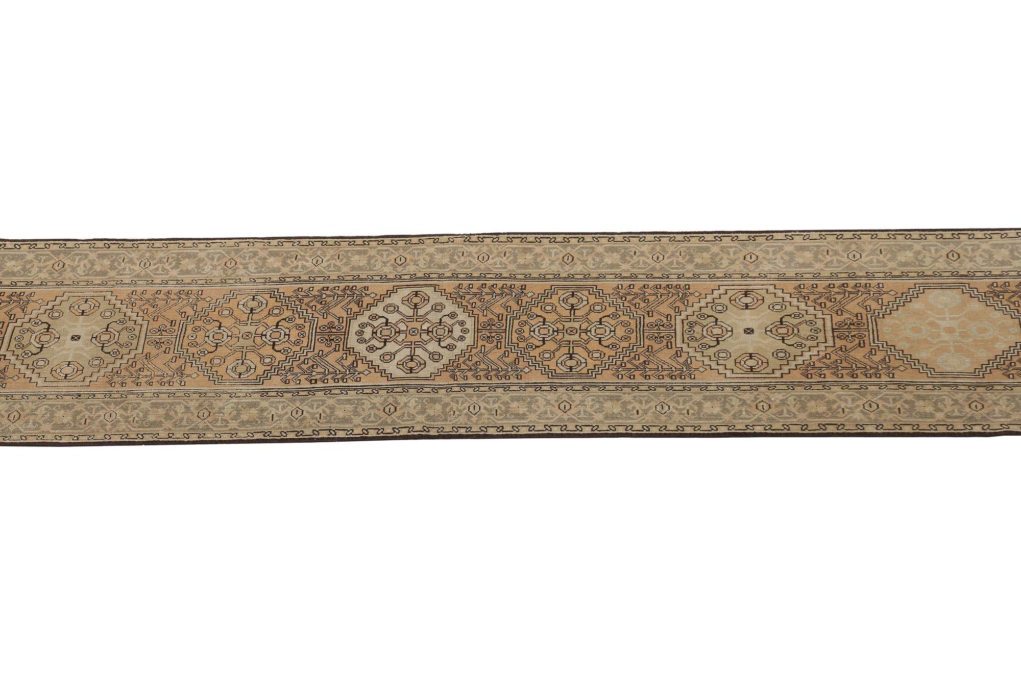 Entdecken Sie die Eleganz des persischen Heriz mit Läufer aus der Zeit um 1910. Dieses exklusive Design aus Wolle und IvoryTaupe ist perfekt, um Ihren Raum zu verschönern.