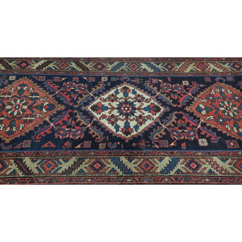 Entdecken Sie die Eleganz des persischen Heriz mit Läufer aus der Zeit um 1910. Dieses exklusive Design aus Wolle und Marineblau ist perfekt, um Ihren Raum zu verschönern.