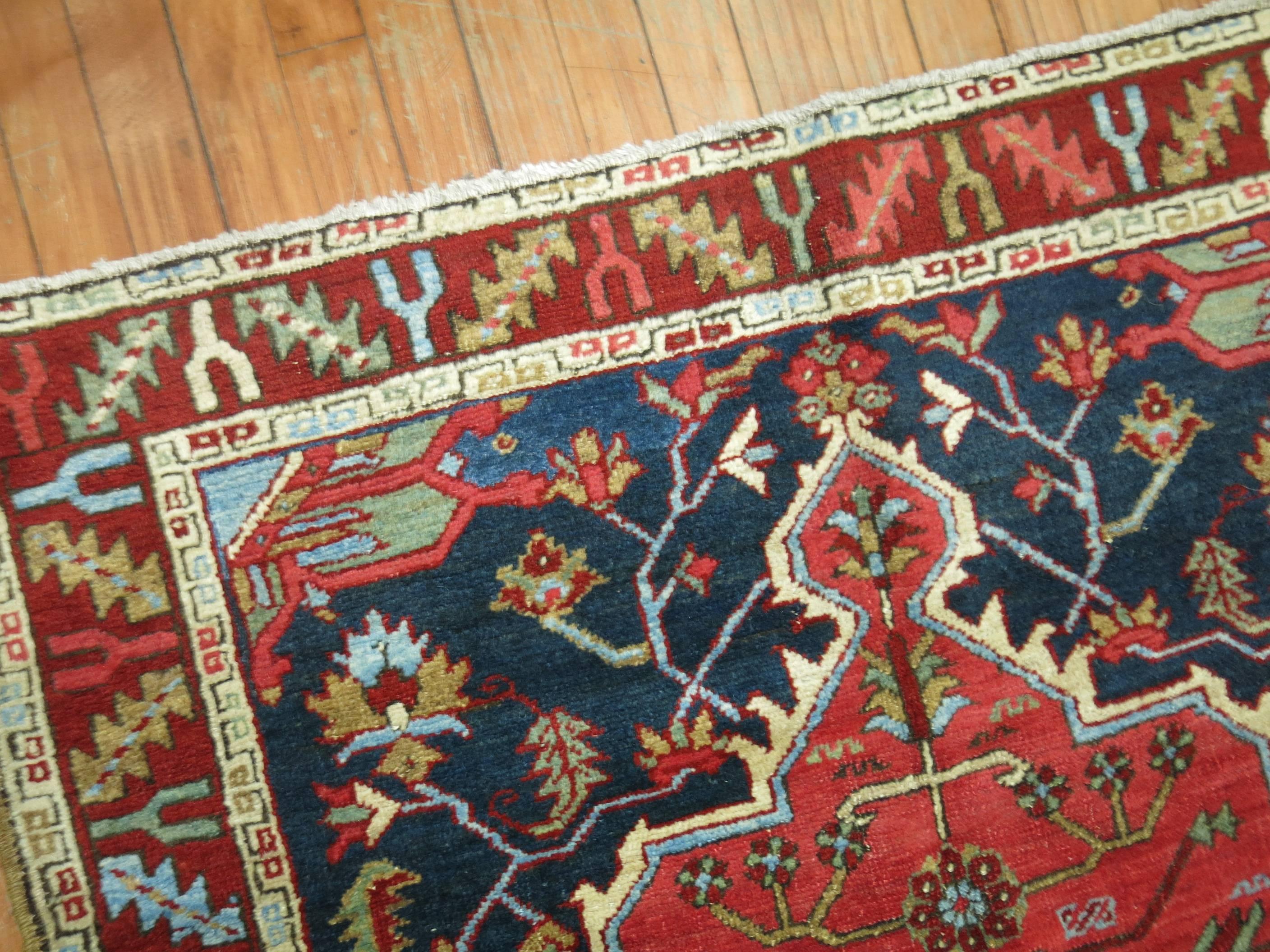 Square shaped antique Persian Heriz rug in rich navy blue and red.