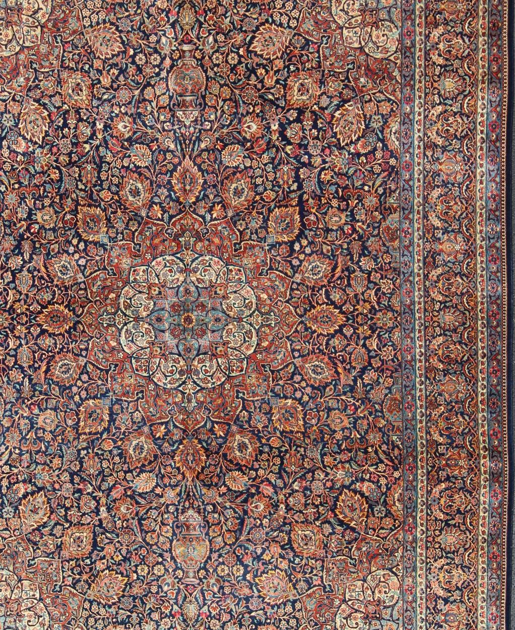 Fine Kashan red and blue antique Persian Kashan rug with Arabesque blossom design, rug EB-CON1-13001, country of origin / type: Iran / Kashan, circa 1910

Distinct colors that are similar yet starkly rendered flow alongside each other in this