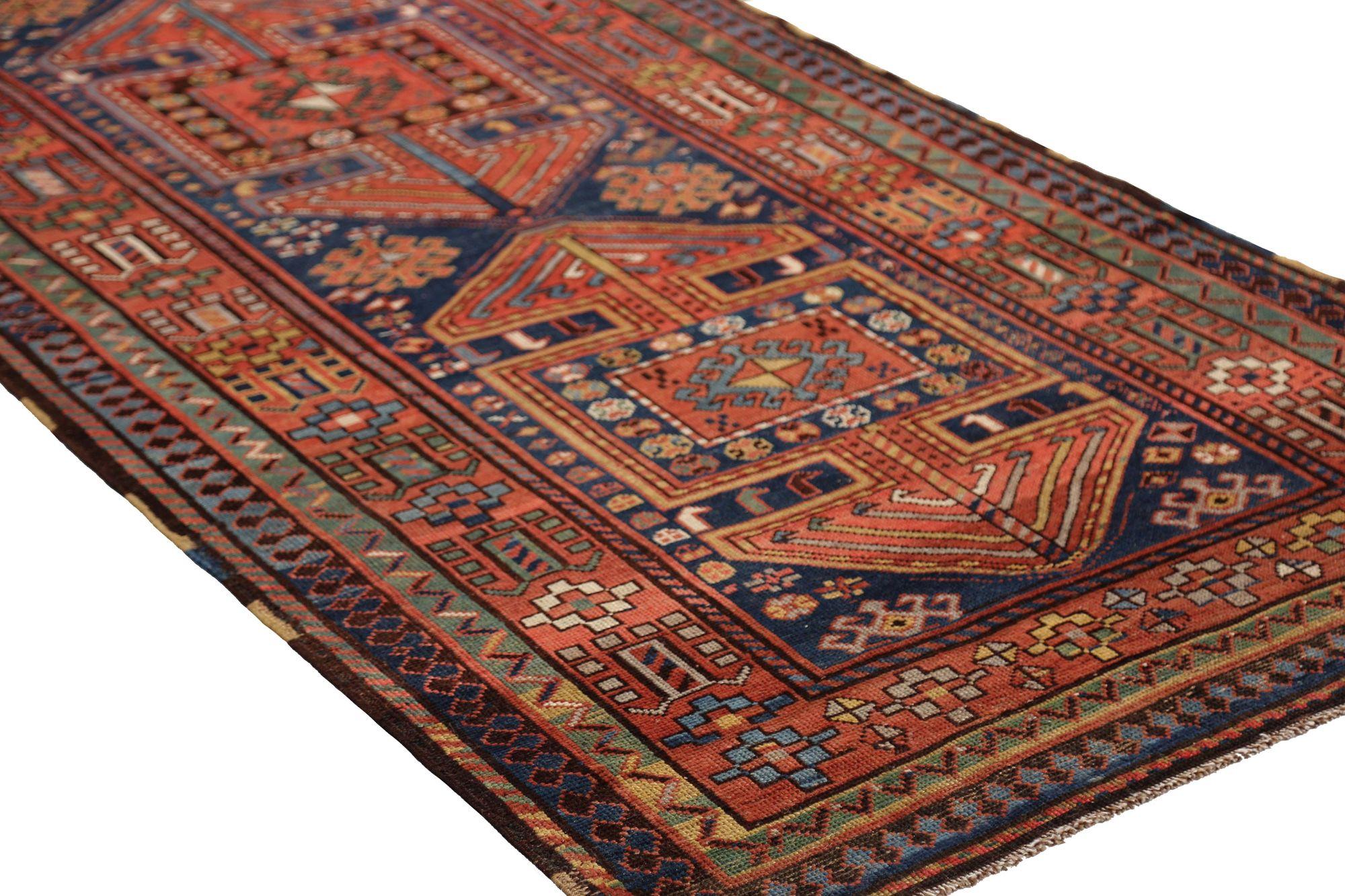Entdecken Sie die Eleganz des persischen Kazak mit dem Läufer von CIRCA 1910. Dieses exklusive Design aus Wolle und Marineblau-Rot ist perfekt, um Ihren Raum zu verschönern.