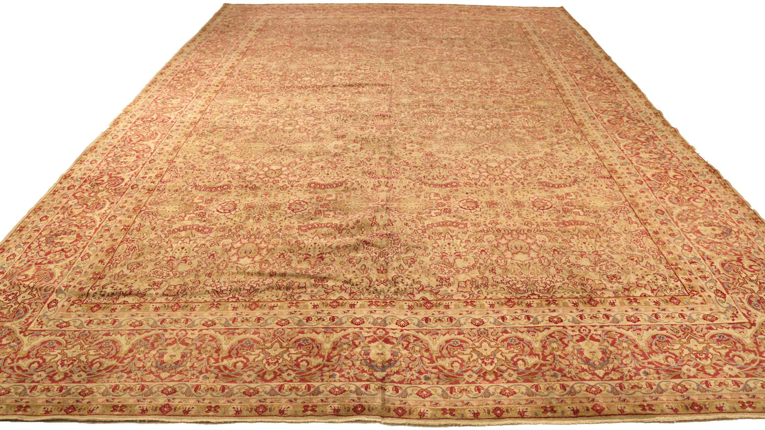 Entdecken Sie die Eleganz des persischen Kerman mit einem übergroßen Teppich von CIRCA 1910. Dieses exklusive Design aus Wolle und Elfenbeinrot ist perfekt, um Ihren Raum zu verschönern.