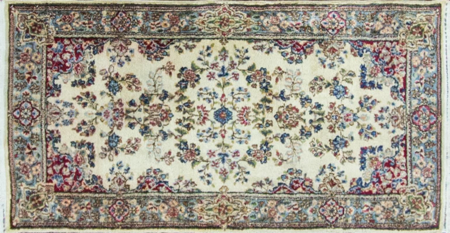 Handmade Persian Kerman rug with a colorful floral motif on an ivory field, circa 1940. Measures: 2'6