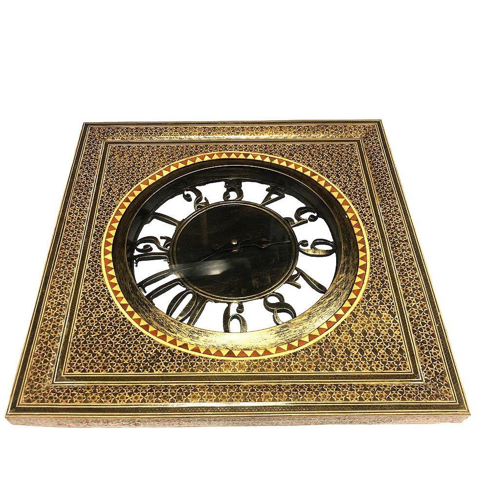 The Persian Khatam Kari Marquetry Mosaic Square Wall Clock is a stylish blend of mixed materials. It features a striking mosaic design with metallic speckles and natural wood accents. This unique timepiece combines modern and rustic elements, making