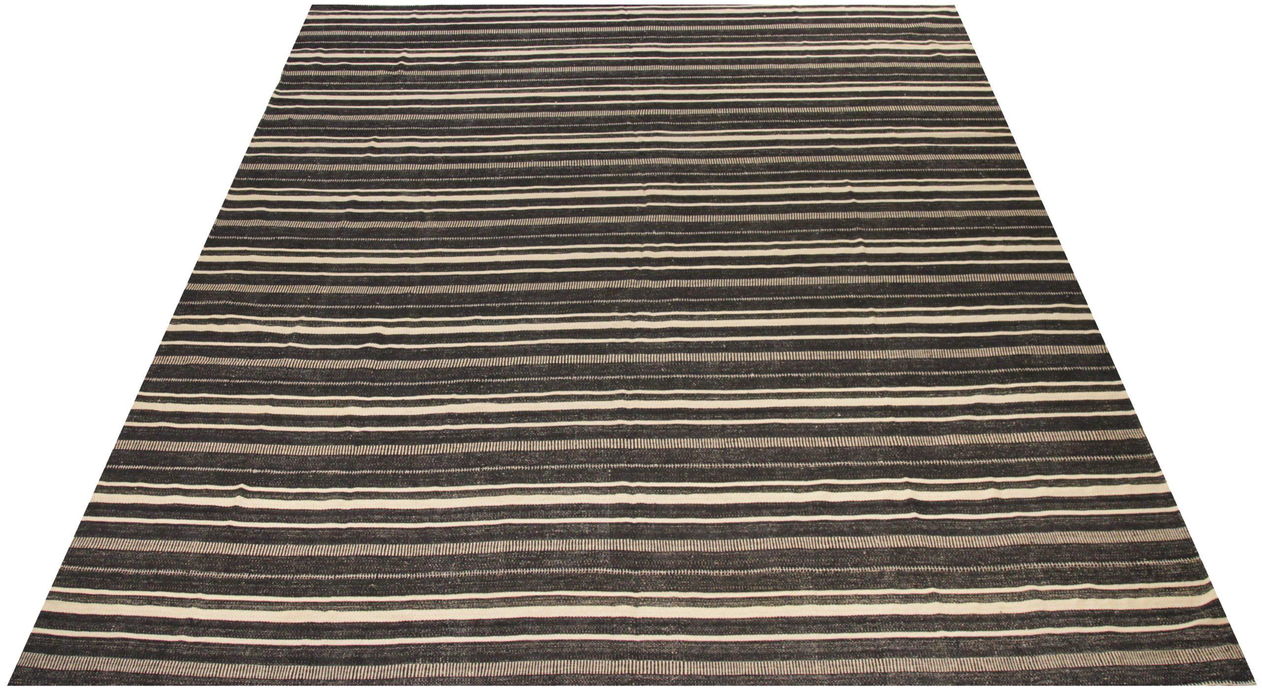 Entdecken Sie die Eleganz eines persischen Kilims mit einem übergroßen Teppich von CIRCA 1910. Dieses exklusive Design aus Wolle und Braun-Elfenbein ist perfekt, um Ihren Raum zu verschönern.