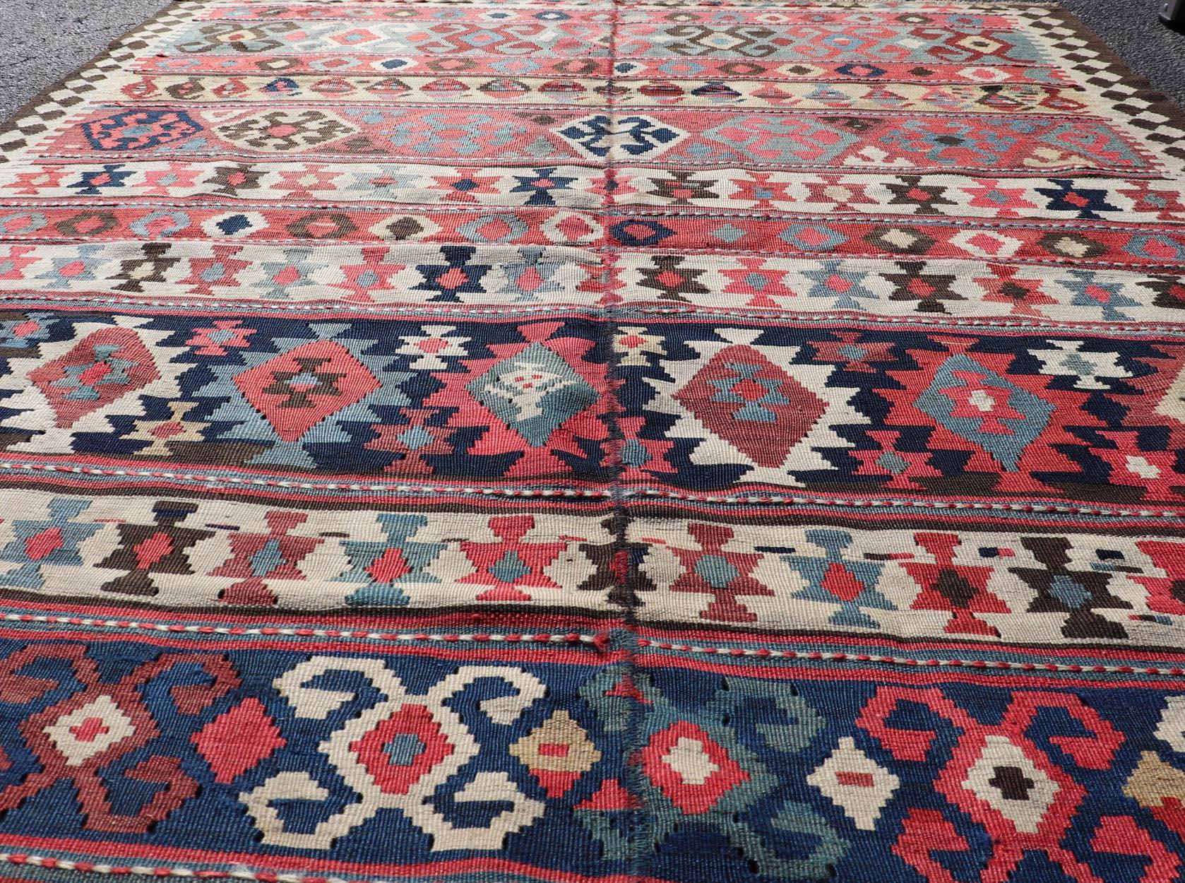 Hand-Woven Persian Kilim Rug with Bold Tribal Geometric Patterns in Vivid Colors 4'9 x 6'9 For Sale