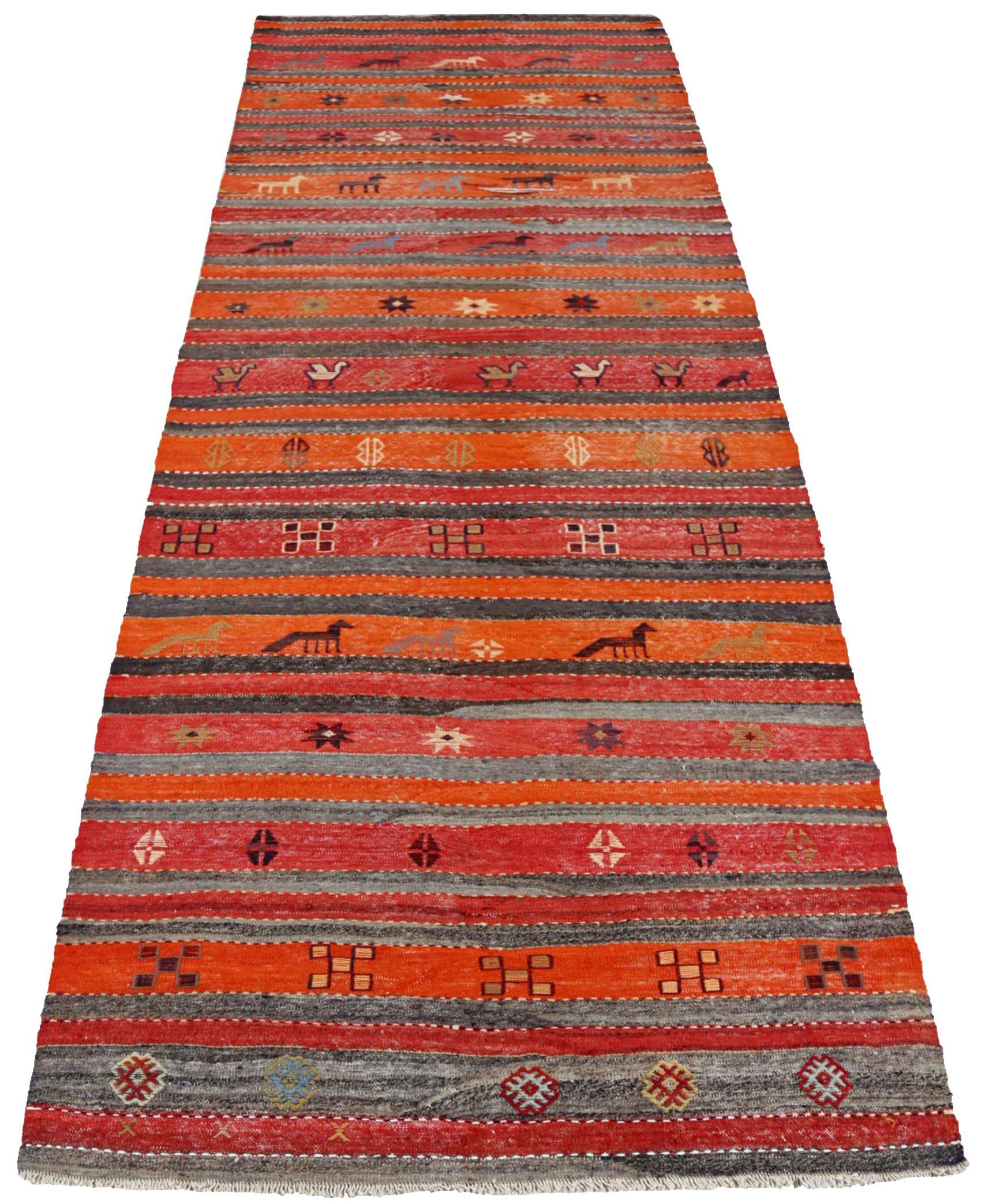 Entdecken Sie die Eleganz des persischen Kilim mit dem Läufer von CIRCA 1910. Dieses exklusive Design in den Farben Wolle und BlauGrauElfenbeinOrangeRot ist perfekt, um Ihren Raum zu verschönern.