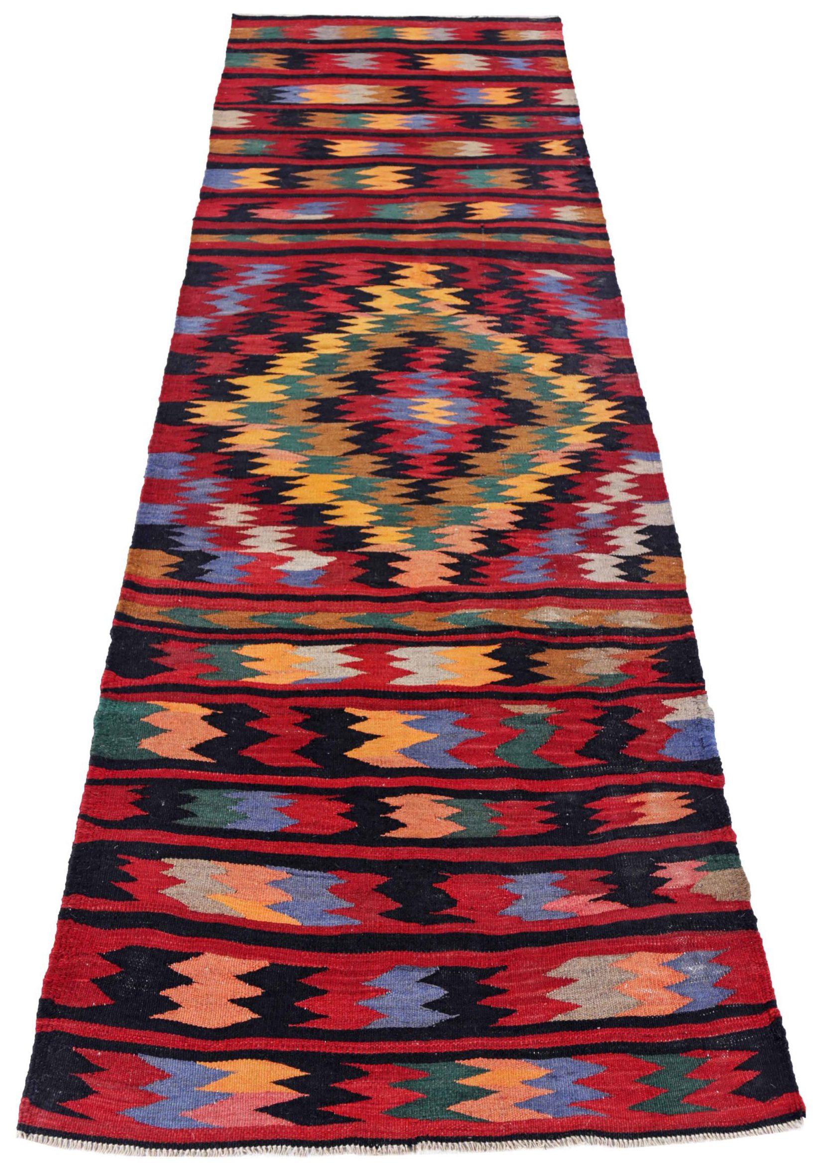 Entdecken Sie die Eleganz des persischen Kilim mit dem Läufer von CIRCA 1910. Dieses exklusive Design aus Wolle und BlauGrünRotGelb ist perfekt, um Ihren Raum zu verschönern.