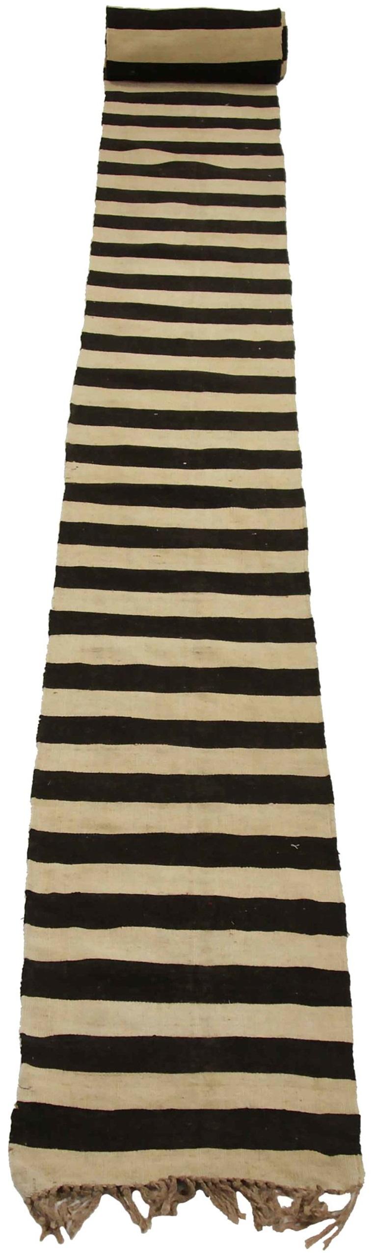 Entdecken Sie die Eleganz des persischen Kilim mit dem Läufer von CIRCA 1910. Dieses exklusive Design aus Wolle und Braun-Elfenbein ist perfekt, um Ihren Raum zu verschönern.