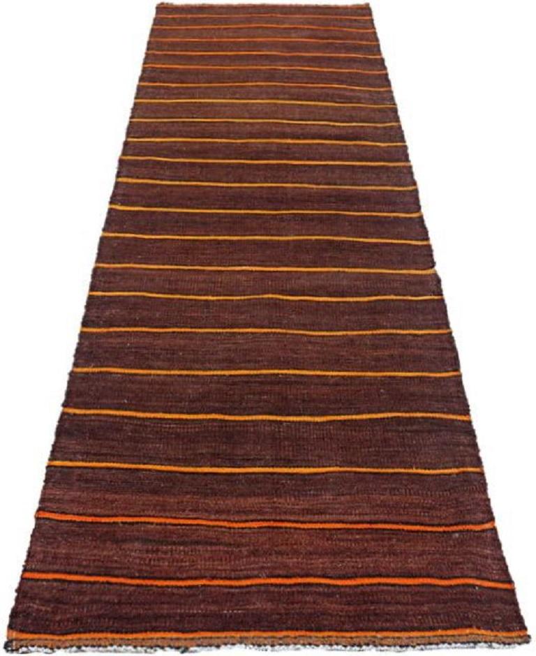 Scopri l'eleganza del tappeto persiano Rug & Kilim del 1910. Progettato con lana e giallo-arancio, questo design esclusivo è perfetto per valorizzare il tuo spazio.
