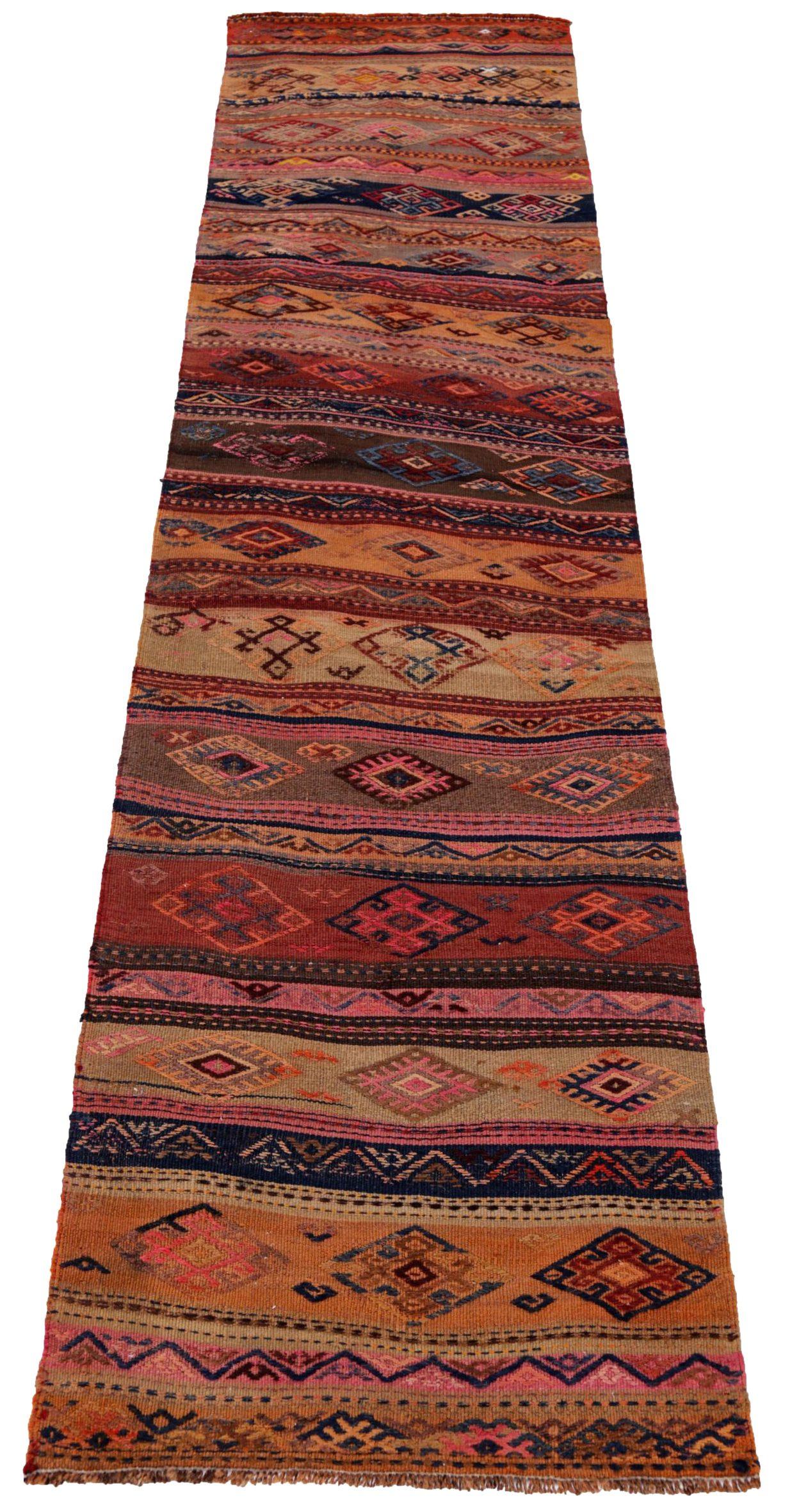 Entdecken Sie die Eleganz des persischen Kilim mit dem Läufer von CIRCA 1910. Dieses exklusive Design aus Wolle und OrangePinkYellow ist perfekt, um Ihren Raum zu verschönern.