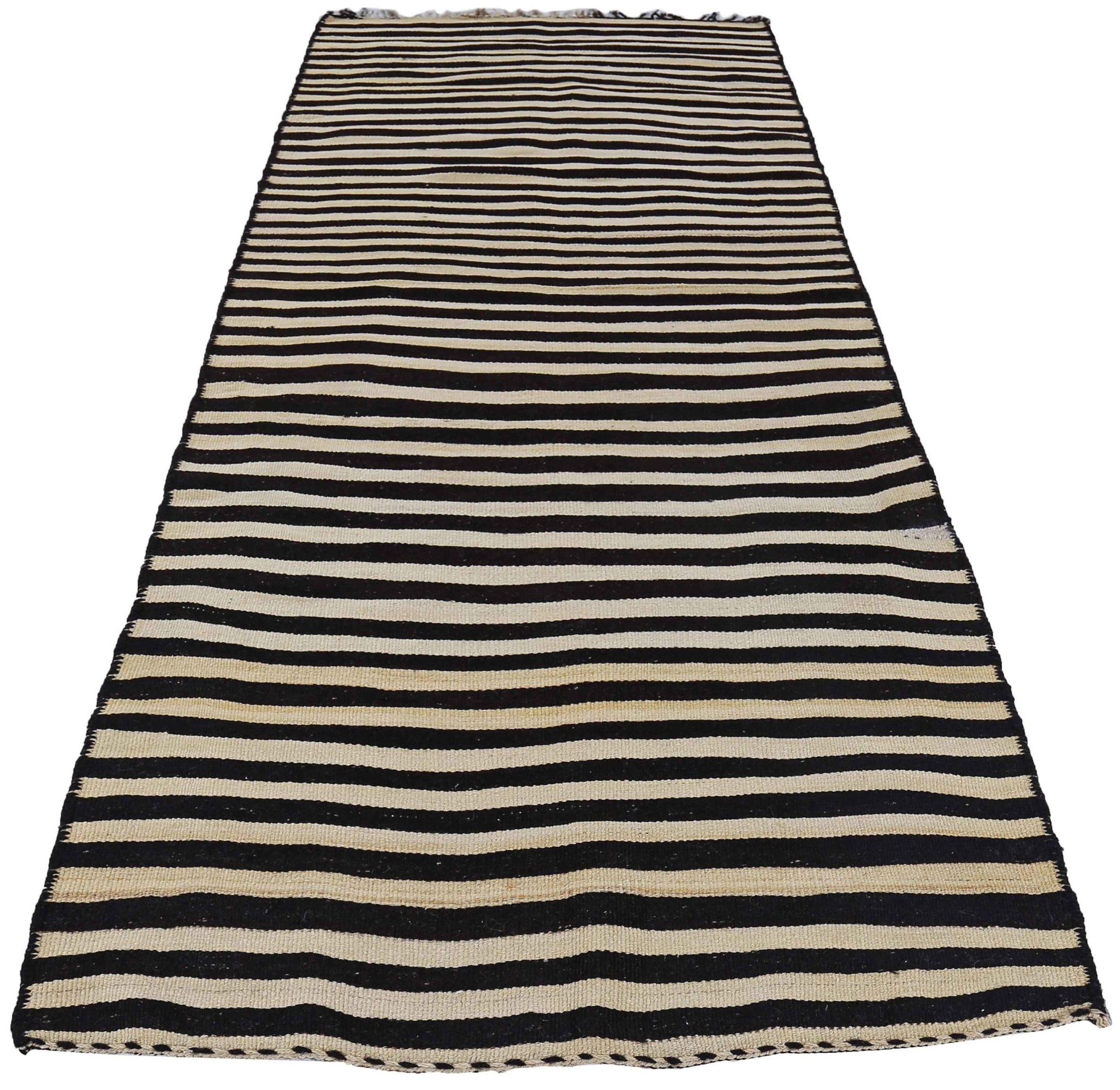 Descubre la elegancia del Kilim persa con una pequeña alfombra de circa 1910. Diseñado con lana y marrón-marfil, este diseño exclusivo es perfecto para realzar tu espacio.