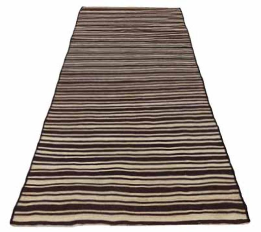 Entdecken Sie die Eleganz eines persischen Kilims mit einem kleinen Teppich von CIRCA 1910. Dieses exklusive Design aus Wolle und Braun-Elfenbein ist perfekt, um Ihren Raum zu verschönern.