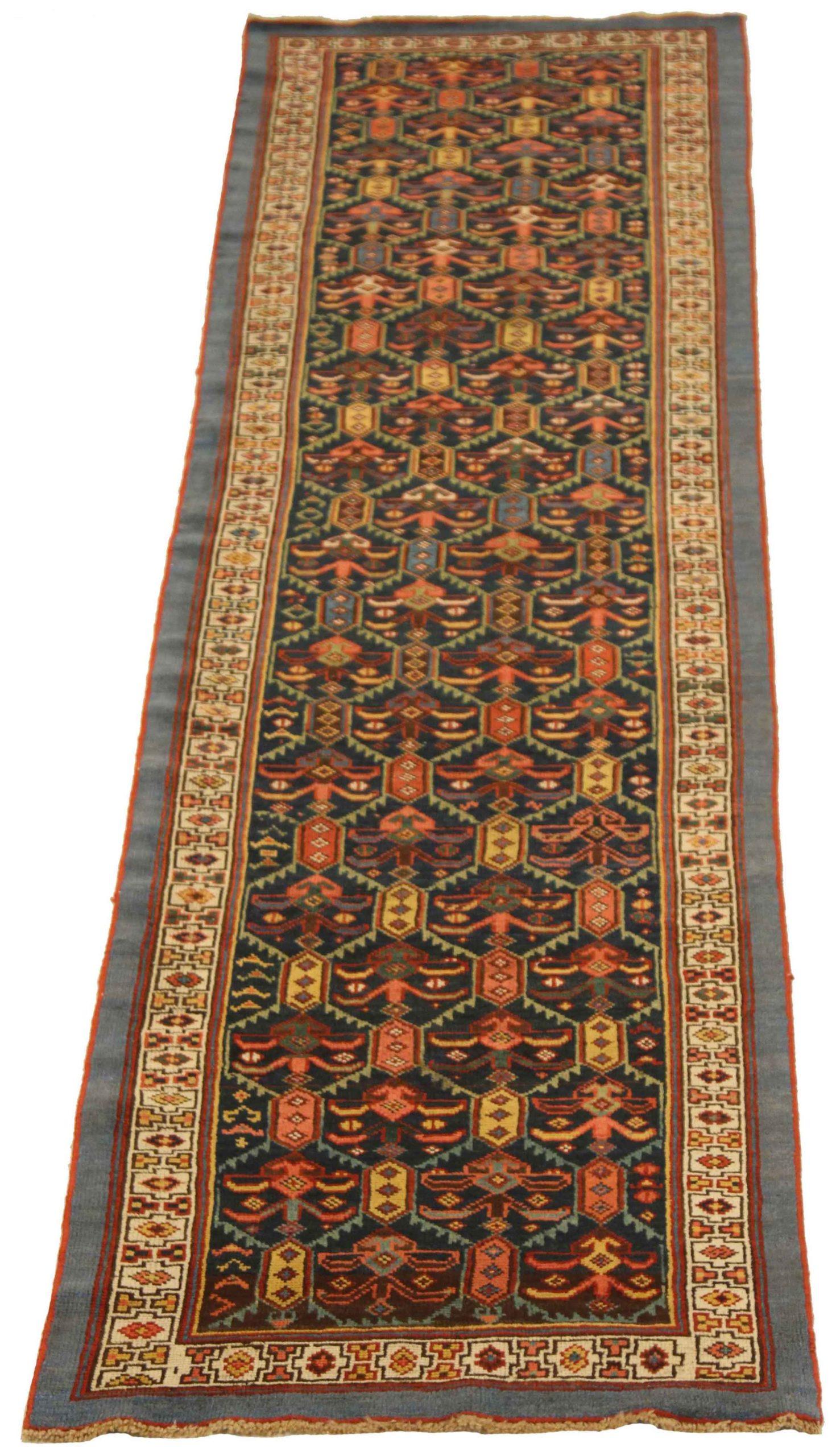 Entdecken Sie die Eleganz des persischen Kolyai mit dem Läufer von CIRCA 1910. Dieses exklusive Design aus Wolle in den Farben BlauElfenbeinMarineblauRosaGelb ist perfekt, um Ihren Raum zu verschönern.