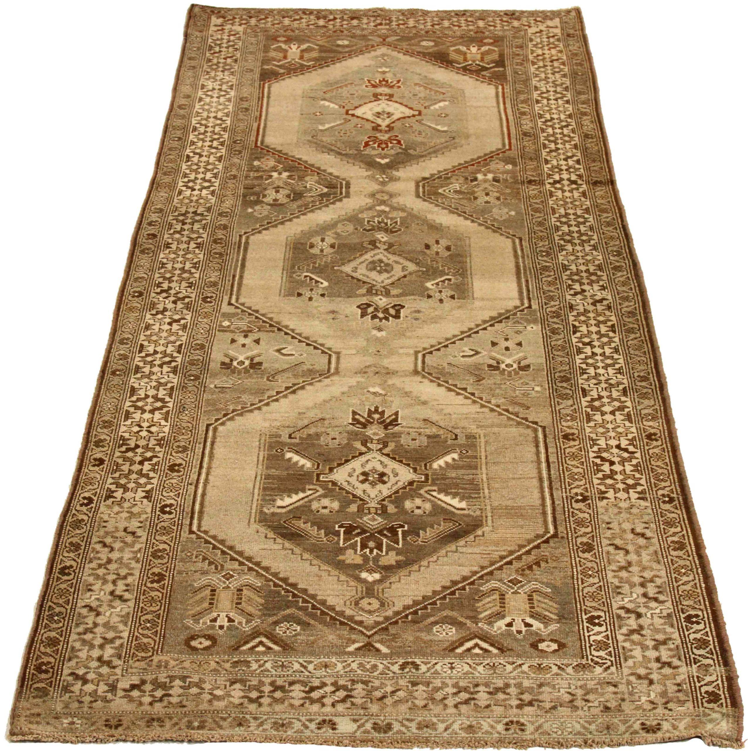 Entdecken Sie die Eleganz des persischen Kolyai mit dem Läufer von CIRCA 1910. Dieses exklusive Design aus Wolle und Braun-Elfenbein-Taupe ist perfekt, um Ihren Raum zu verschönern.