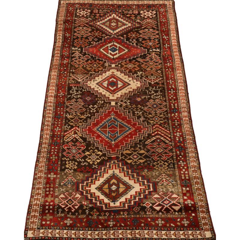 Scopri l'eleganza del tappeto persiano curdo di piccole dimensioni del 1940. Progettato con lana e nero-avorio-rosso, questo design esclusivo è perfetto per valorizzare il tuo spazio.