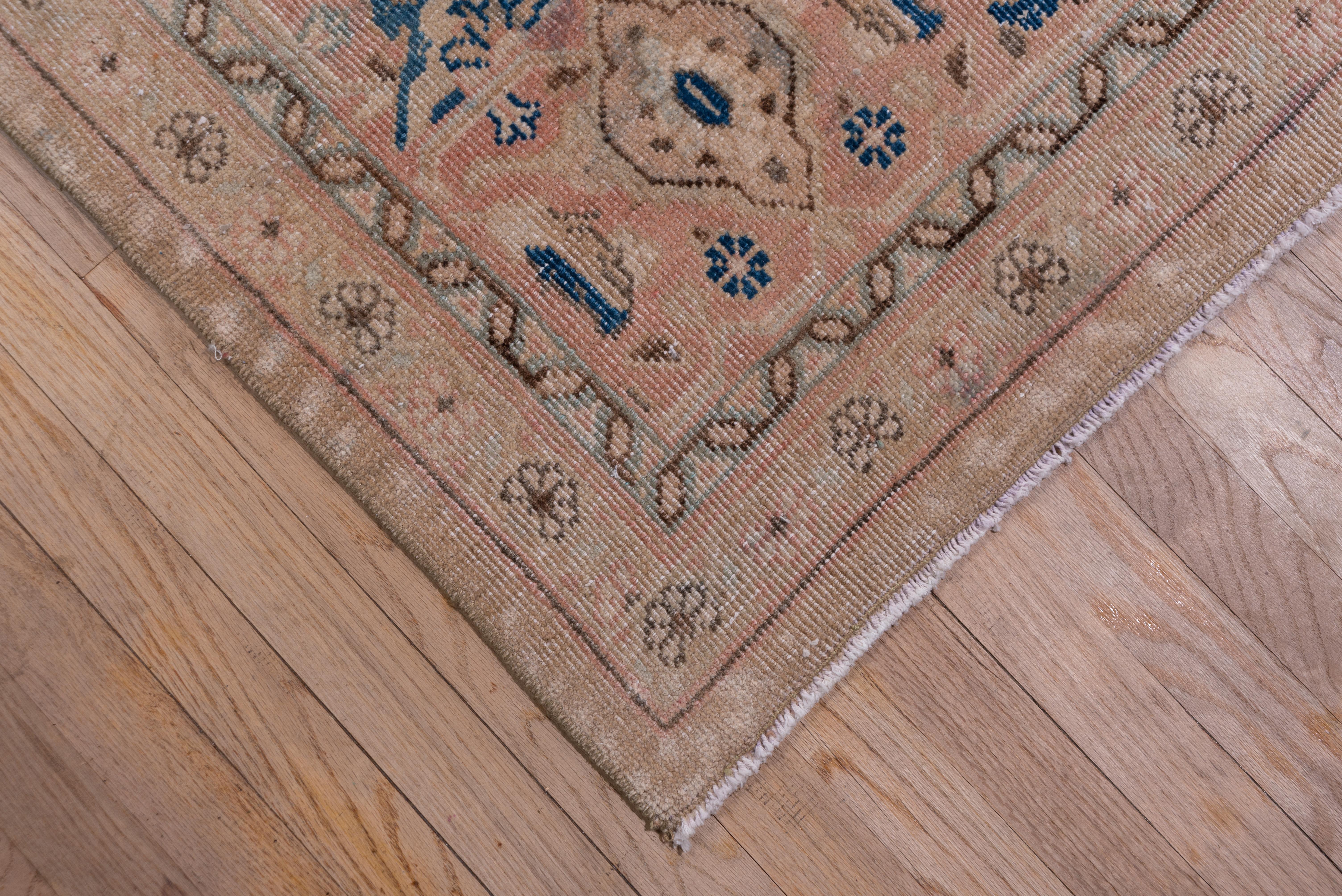 The light buff field of this iconic west Persian rustic carpet supports an allover Herati design within stepped Herati corners and an framing buff border with simple turtle escutcheons.