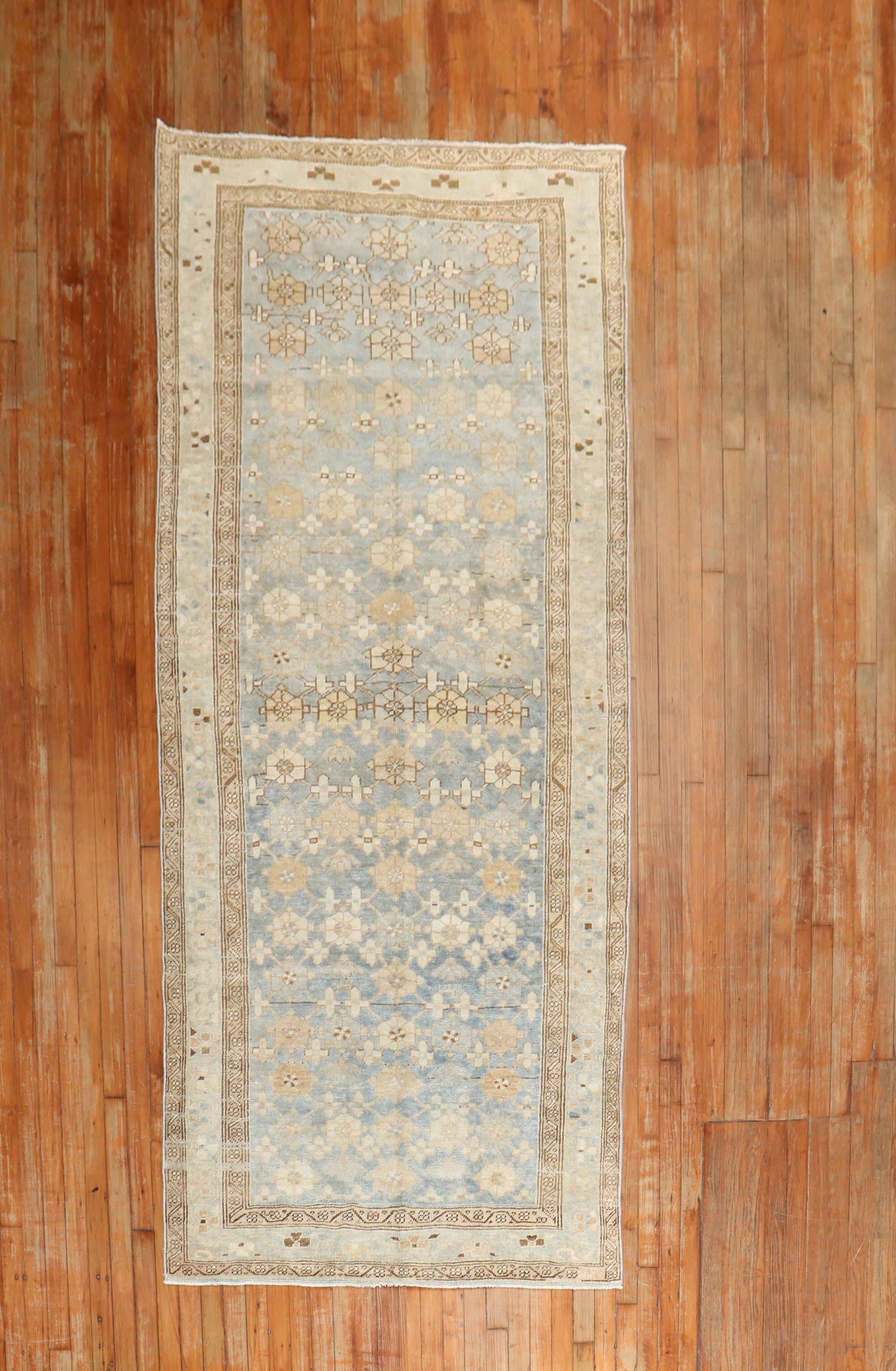 An antique Persian Malayer intermediate size rug from the 2nd quarter of the 20th century in blue, brown, sand, gray, and camel tones

Measures: 3'11” x 9'7''.