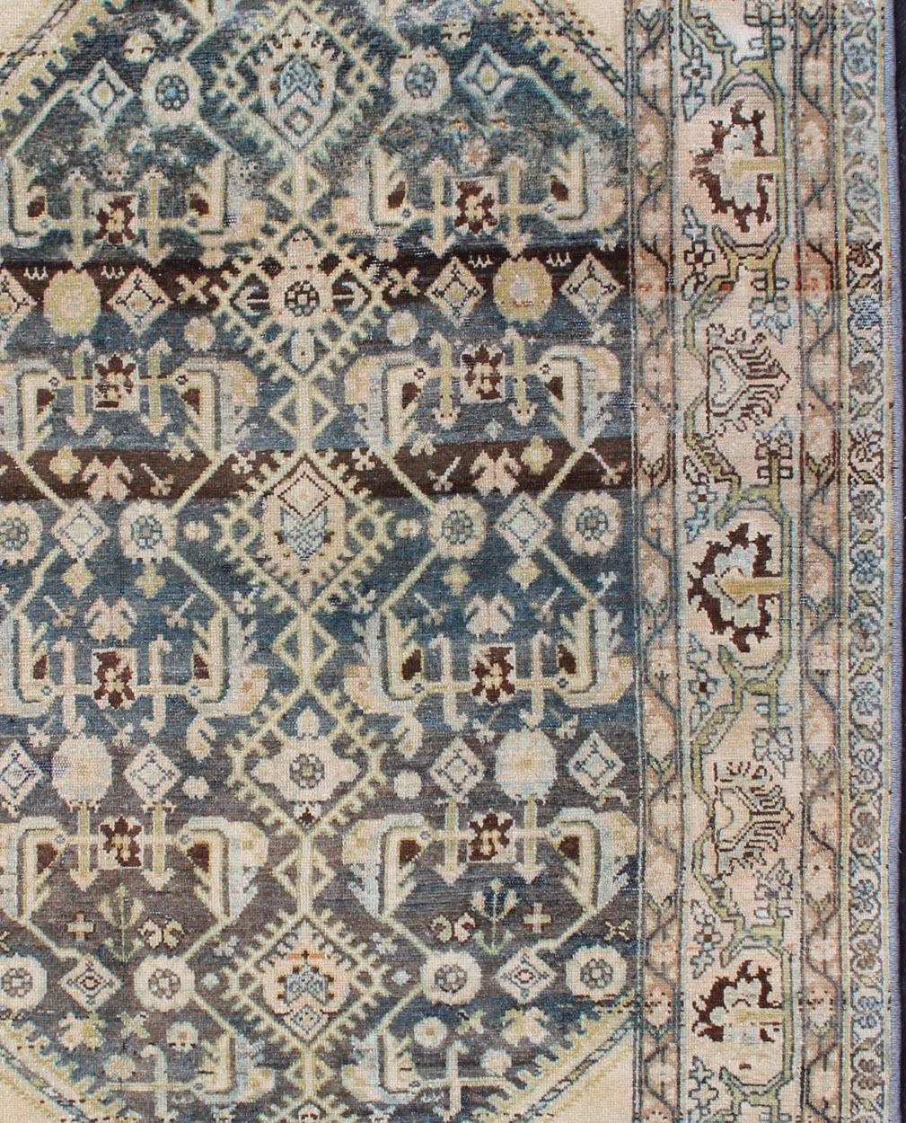 Tapis persan ancien à champ bleu et corniches crème, tapis SUS-1908-3, pays d'origine / type : Iran / Malayer, vers 1910.

Ce tapis persan traditionnel Malayer du début du XXe siècle se caractérise par un champ central rempli de divers motifs
