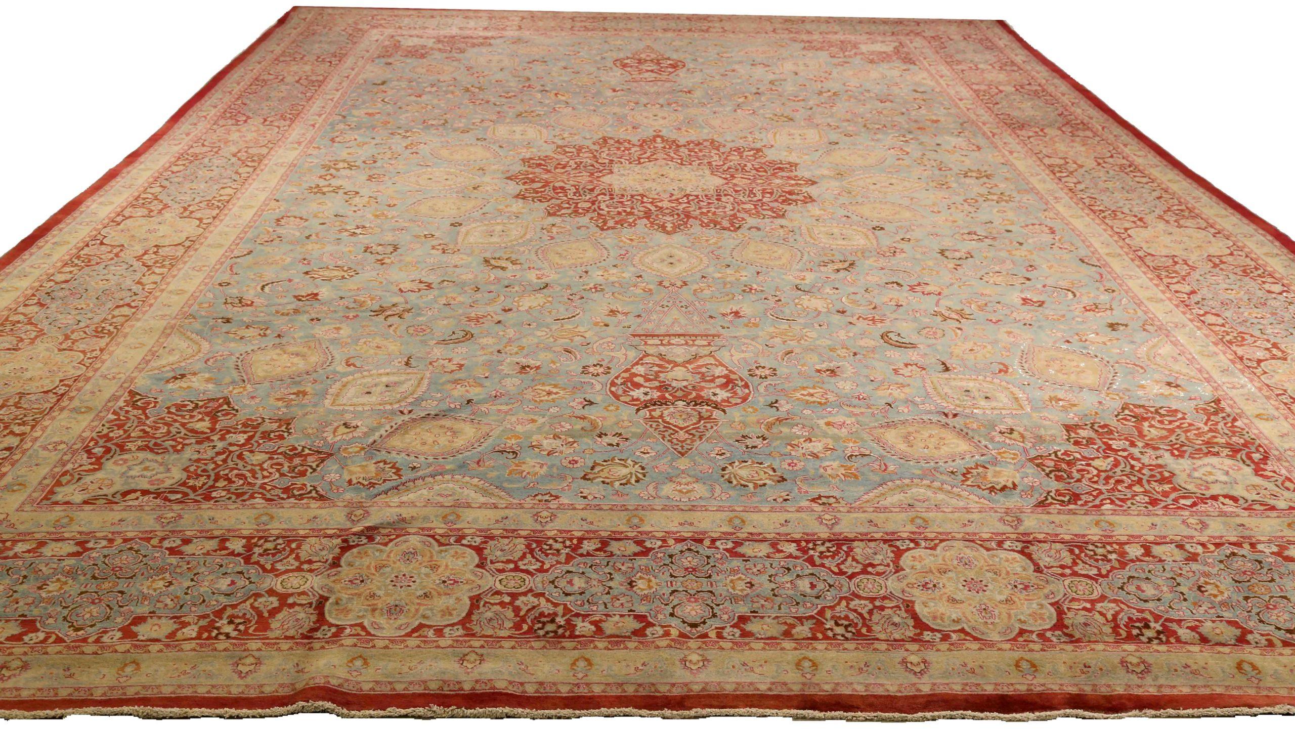 Entdecken Sie die Eleganz des persischen Mashad-Teppichs mit Übergröße aus dem Jahr CIRCA 1910. Dieses exklusive Design aus Wolle und Blau-Elfenbein-Rot ist perfekt, um Ihren Raum zu verschönern.