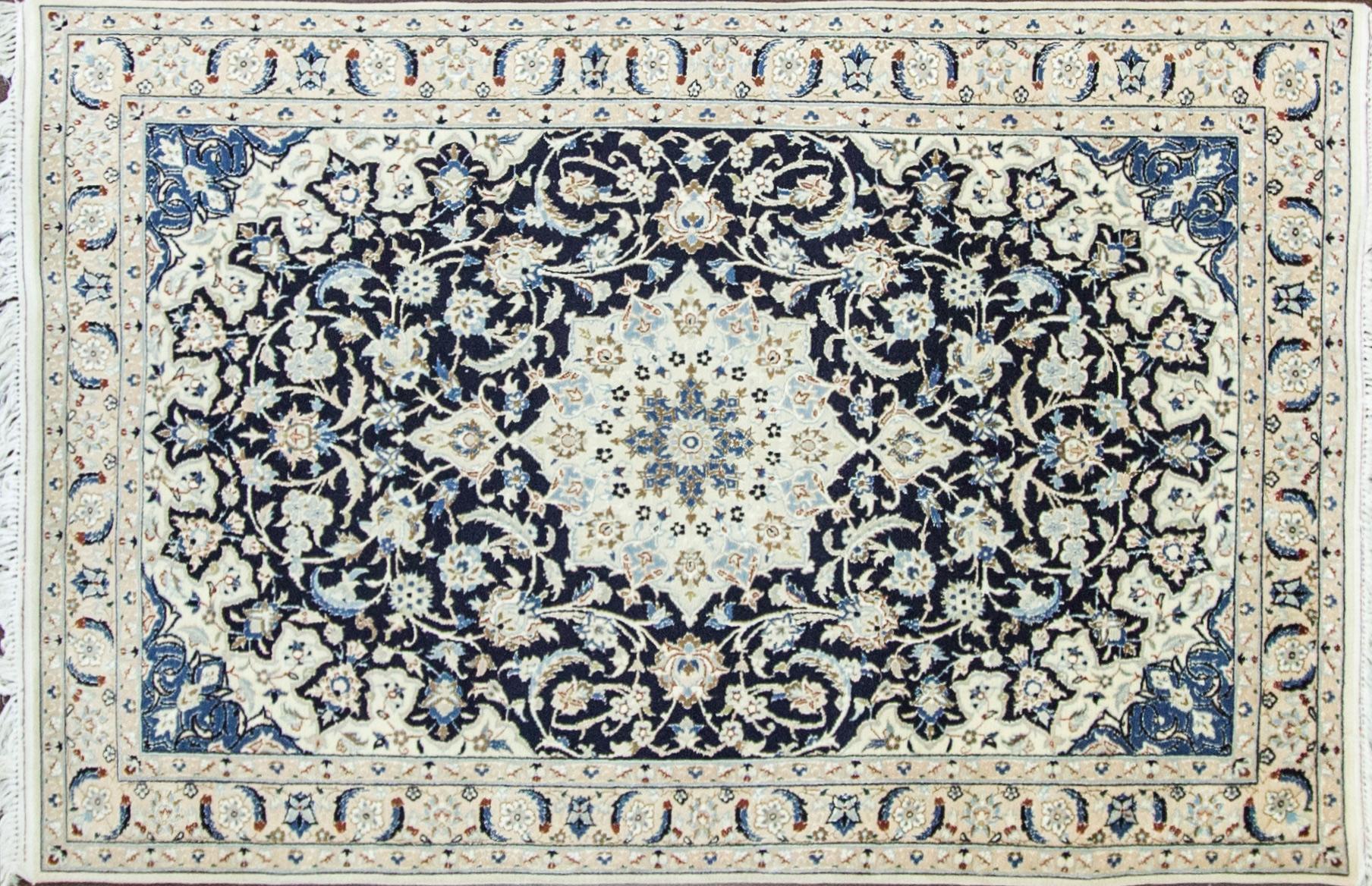 Wool and silk Persian rug.
Nain rugs are constructed using the Persian knot and typically have between 300 and 700 knots per square inch. The pile is usually very high quality wool, clipped short, and silk is often used as highlighting for detail in
