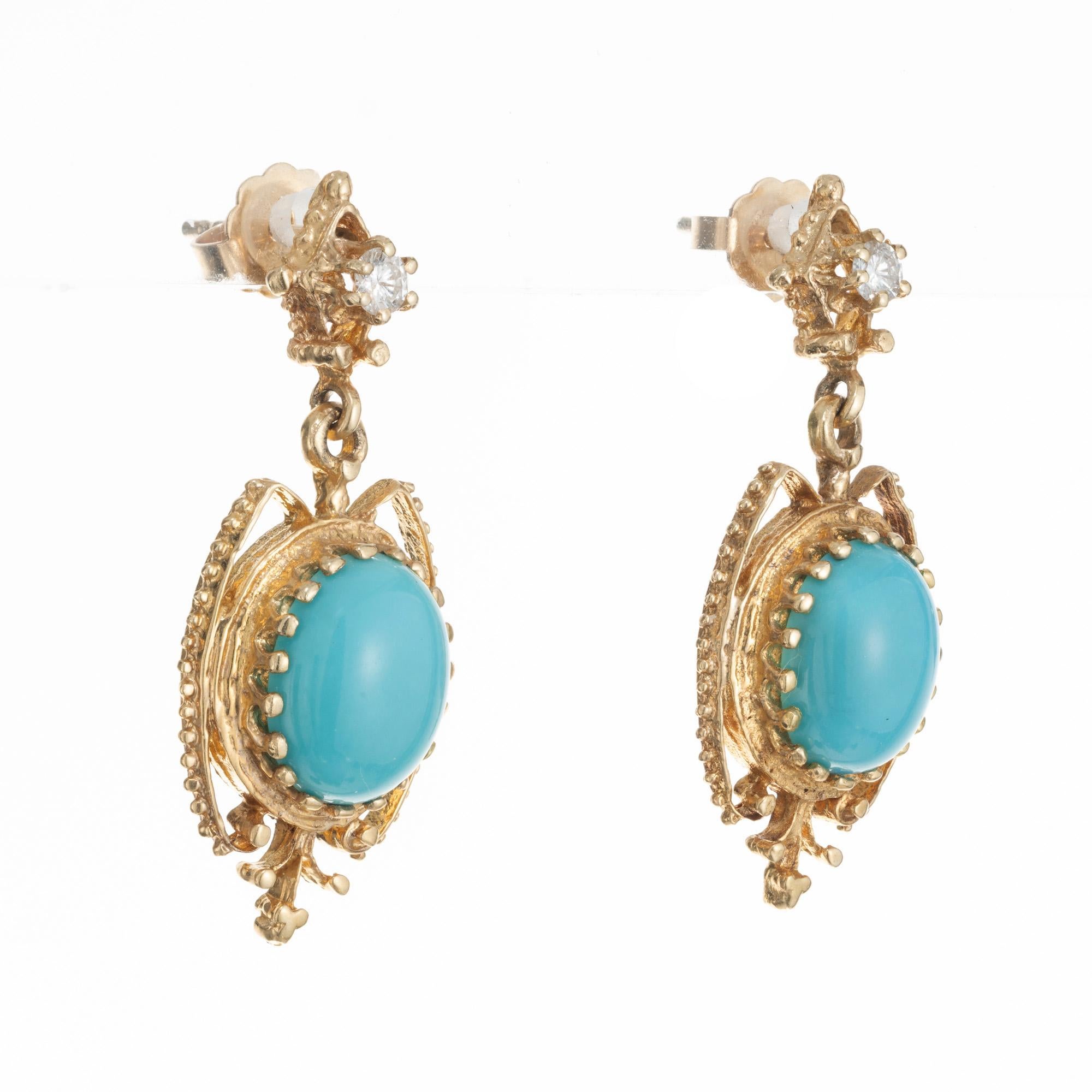 Vintage 1940's late Art Deco Turquoise Diamond dangle earrings. 2 oval cabochon natural, untreated, turquoise mounted in elegantly detailed 14 yellow gold settings. Each gemstone is accented with a round cut diamond. Beading runs along the open work