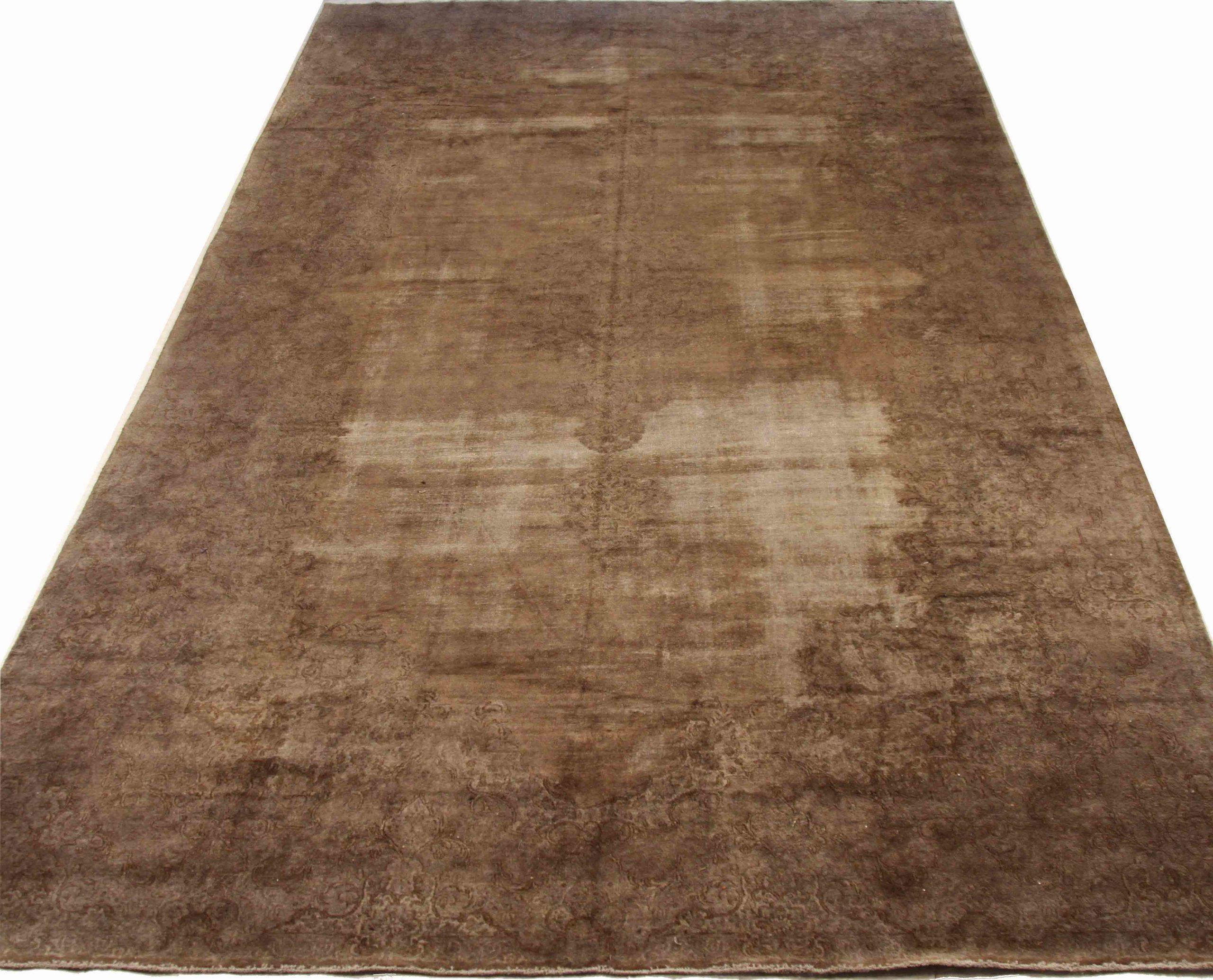 Entdecken Sie die Eleganz eines persischen Overdye-Teppichs in Übergröße aus der Zeit um 1910. Dieses exklusive Design aus Wolle und Braun-Elfenbein ist perfekt, um Ihren Raum zu verschönern.