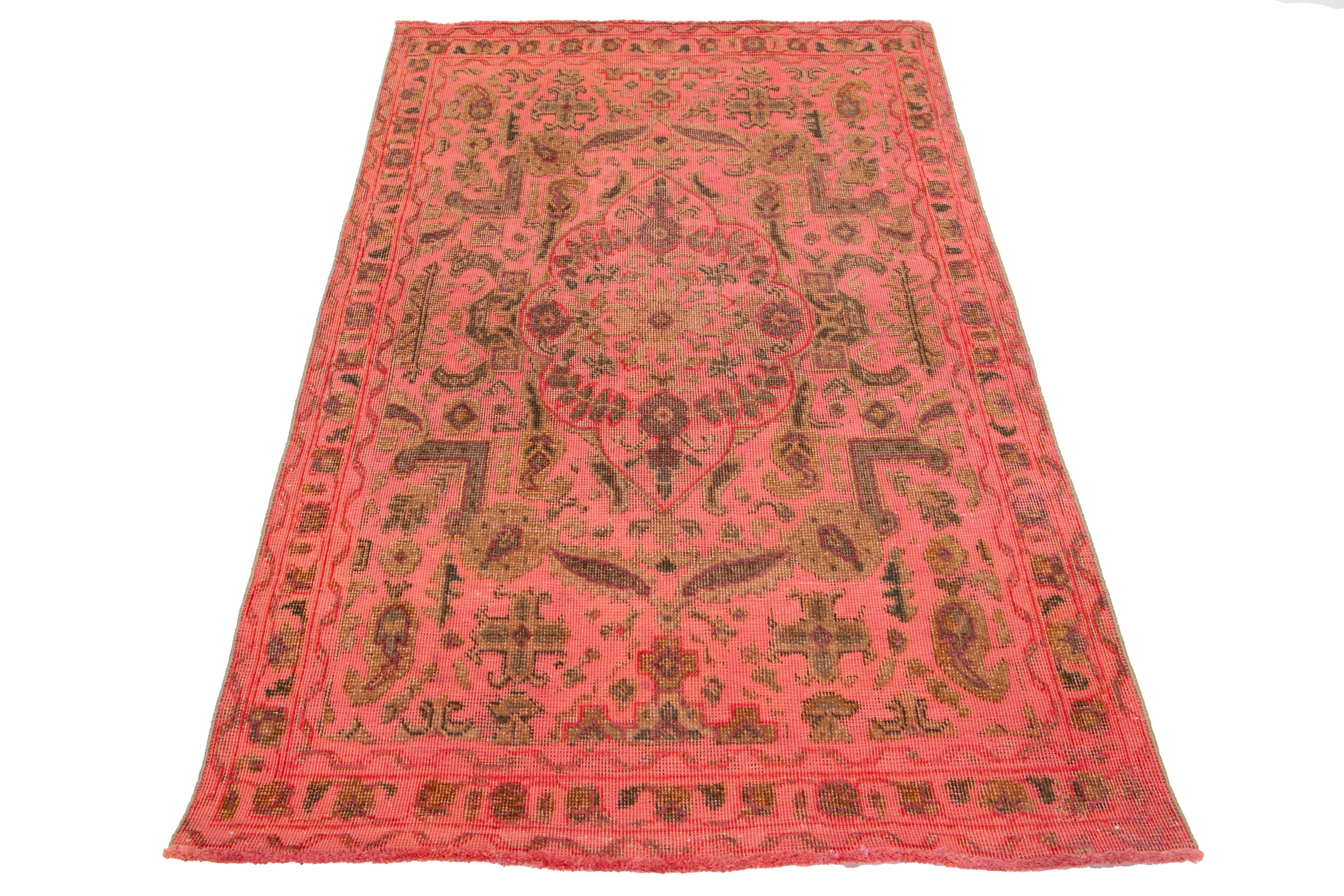 Dieser Vintage-Teppich aus gefärbter persischer Wolle besticht durch sein pink-orangefarbenes Feld mit charmanten braunen Blumenakzenten.

Dieser Teppich misst 3'1