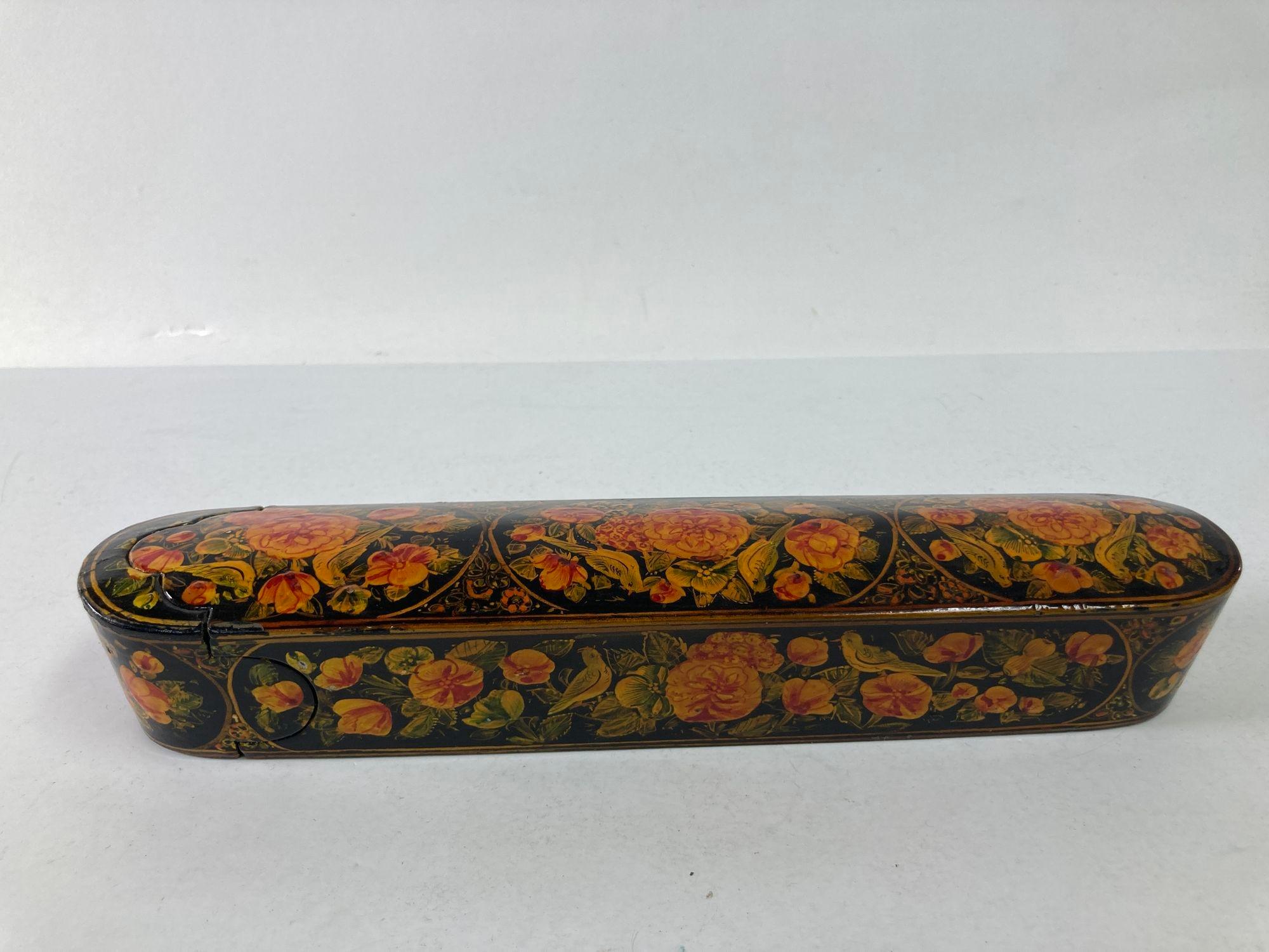 Persian Qajar Lacquer pen box Hand Painted with floral and birds design.
Indo Persian hand painted lacquer pen box in elongated oval shape.
A beautifully decorated scabs pen was on paper mâché, with flowers and birds. 
The pen box is made of two